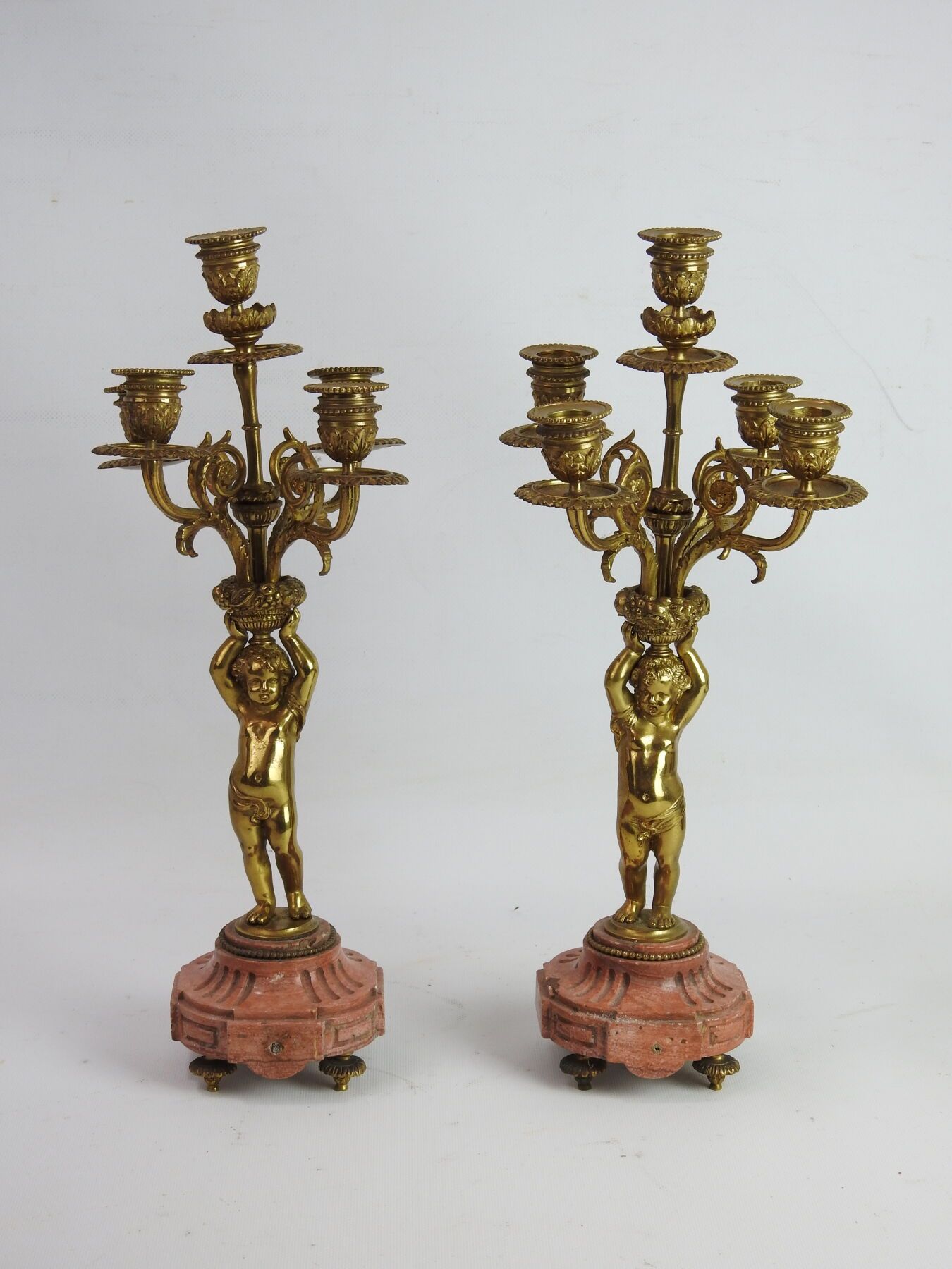 Null 一对镀金的青铜烛台，有五条光臂，装饰着支撑着水果篮的普蒂。拿破仑三世时期。高度：43厘米。一些磨损和撕裂