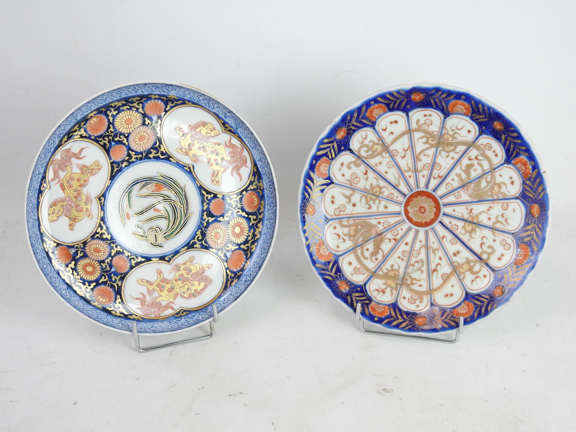 Null 日本：两个用蓝色、红色和金色装饰的瓷质餐盘相遇，称为伊万里，装饰有龙和狗的Fô。19世纪。直径22.5和23厘米。穿着