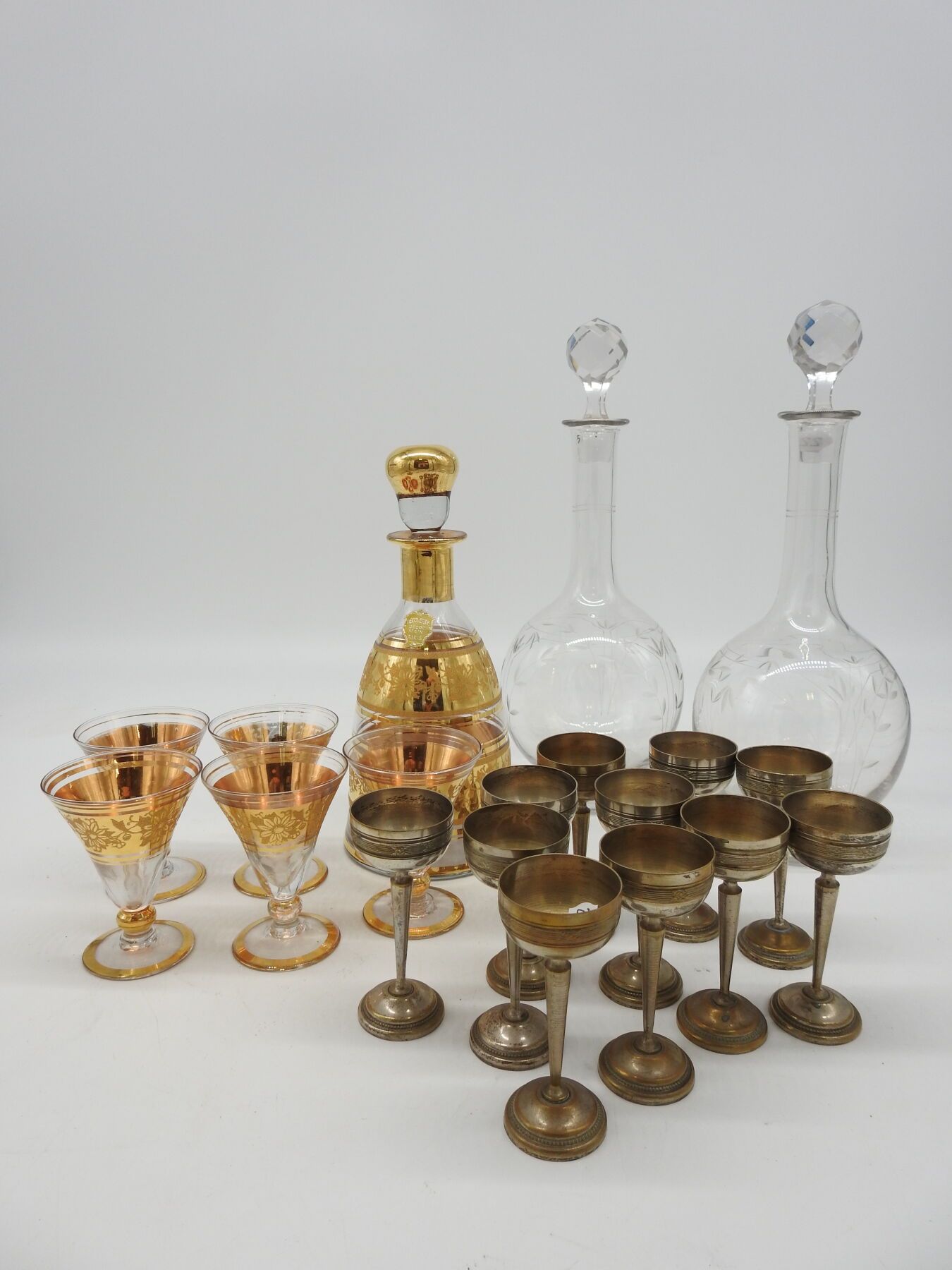 Null 装饰品：玻璃和镀金酒具：一个酒壶和五个杯子

加入一对刻有树叶的玻璃酒壶

和11个烈酒杯的金属底座