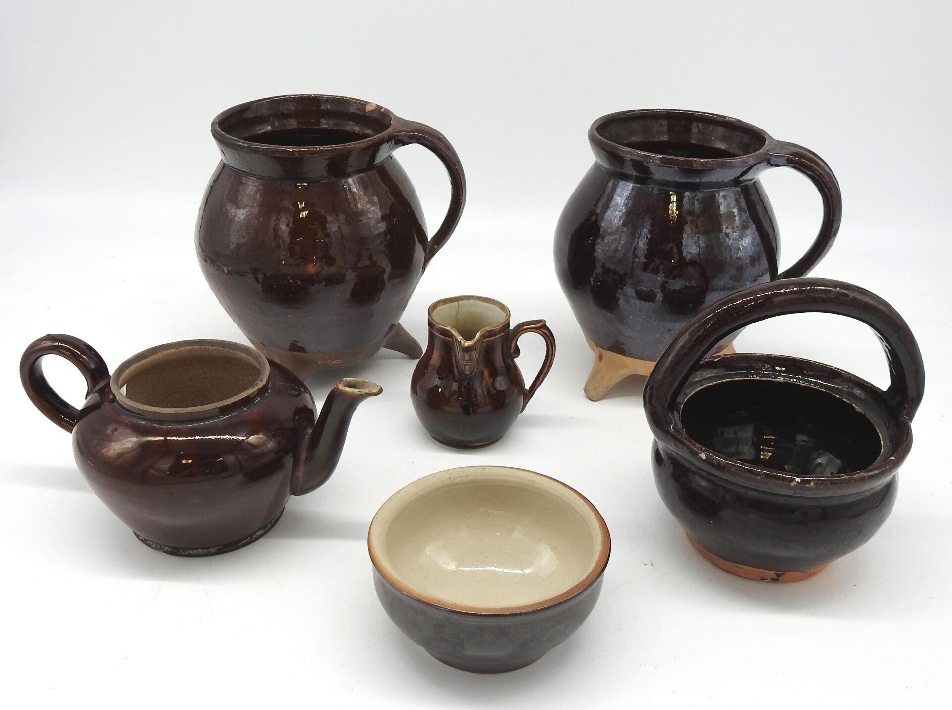 Null 六件棕色釉面陶器。两个三脚架，一个茶壶，一个牛奶壶，一个篮柄壶和一个碗。19世纪。三脚架的高度：19.5厘米。事故和裂缝。