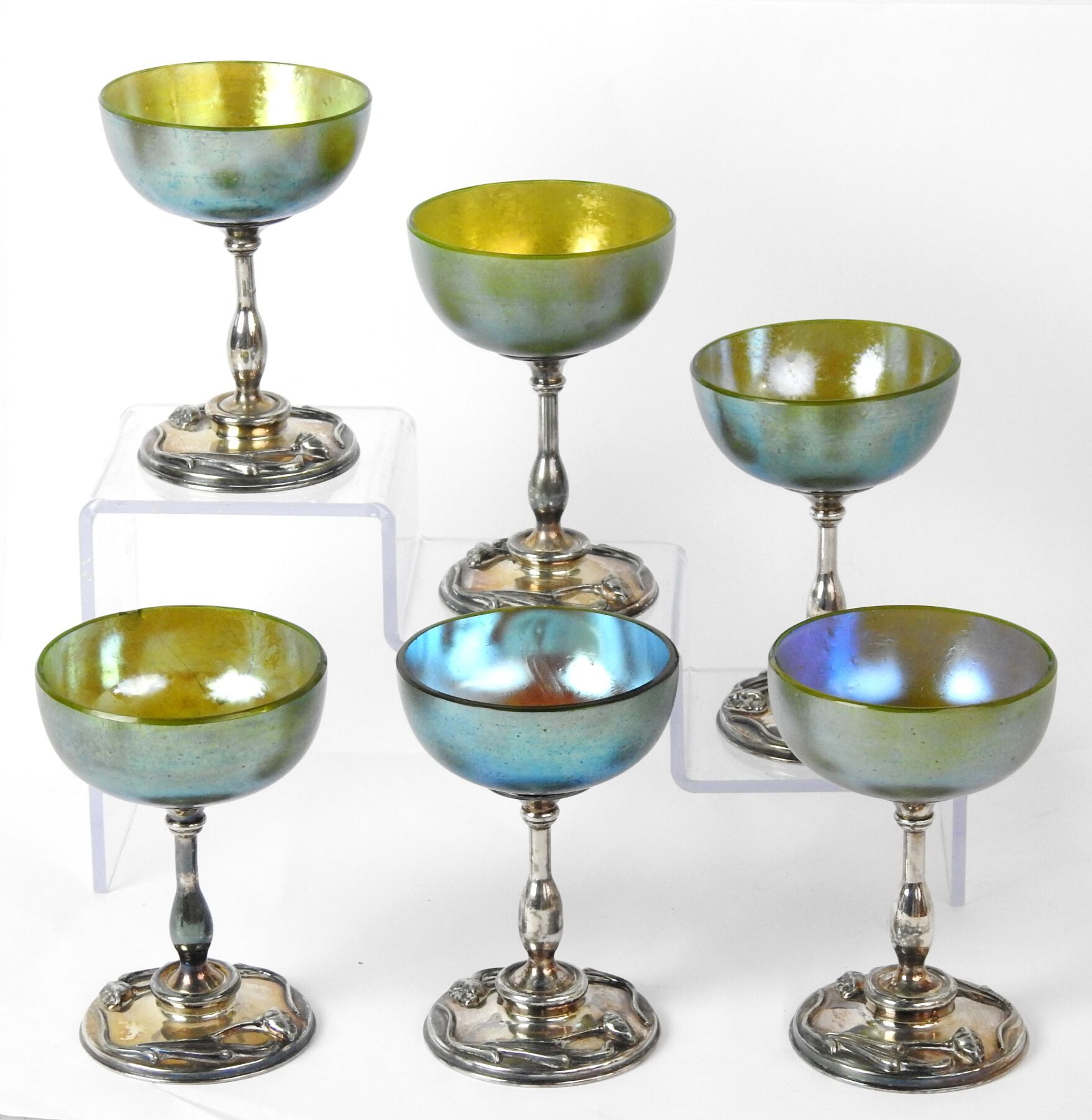 Null 蒂凡尼（的风格）。六个玻璃杯，有强烈的彩虹色，脚下是镀银的金属，有新艺术风格的装饰。签名为 "SCP "的框架。康涅狄格州的梅里登公司。高：13厘米（&hellip;