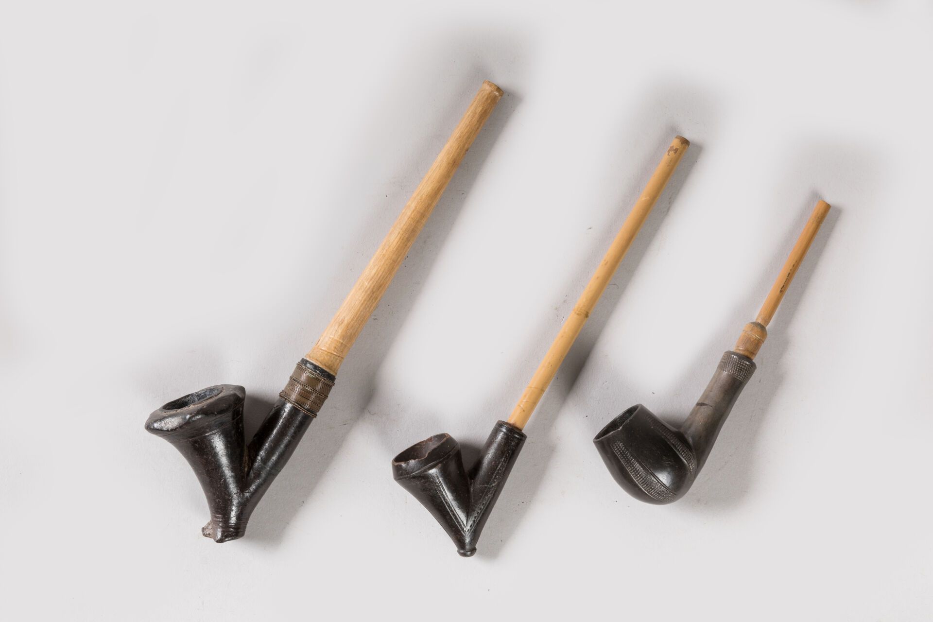 Null 
一套三支烟斗，南非ZULU。




带有自然光泽的木头，黑色滑泥，金属。




长度：15厘米、20.5厘米和23厘米。有一个被重新粘起来了。