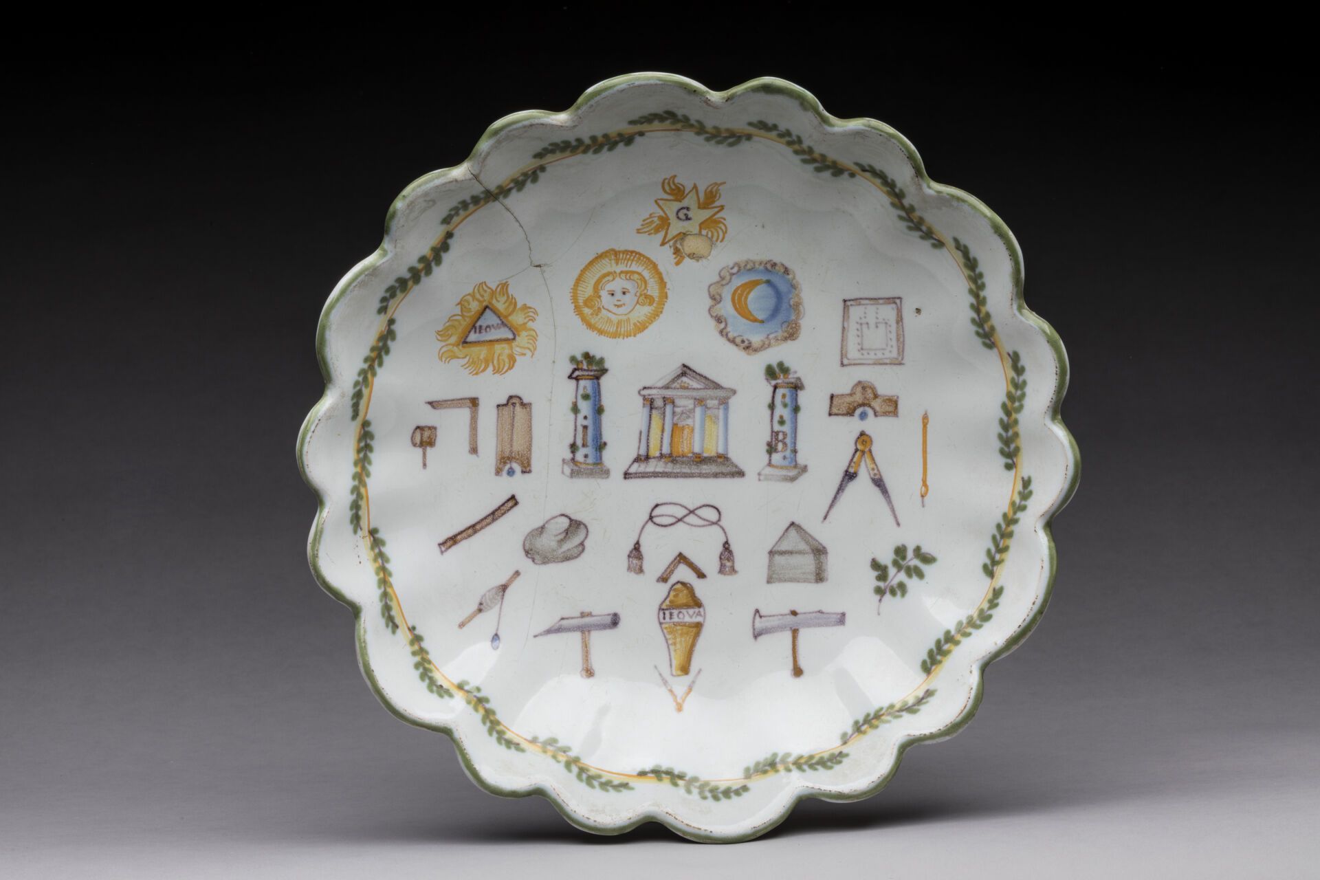 Null MOUSTIERS : 汤盘，陶器中带有石榴裙边，有共济会的装饰，被称为25个符号，花环的叶子和翅膀上的黄网。18世纪晚期。直径：21.5厘米。星形的&hellip;