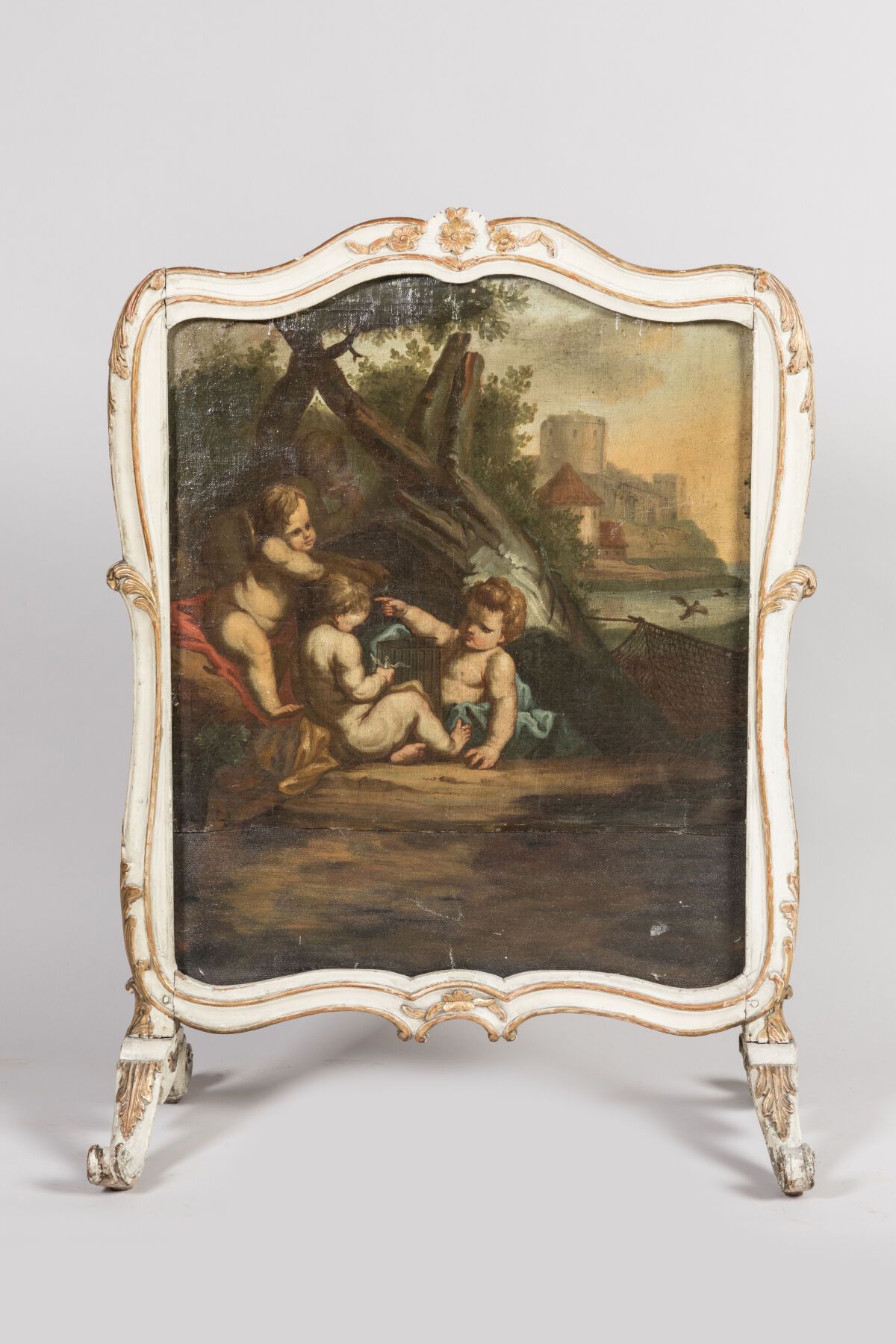 Null 一个奶油色漆面和镀金的木质火屏，叶子上装饰着一幅画布，表现了一个海边背景的儿童场景。18世纪。高度：107厘米-78厘米-40厘米。磨损和撕裂