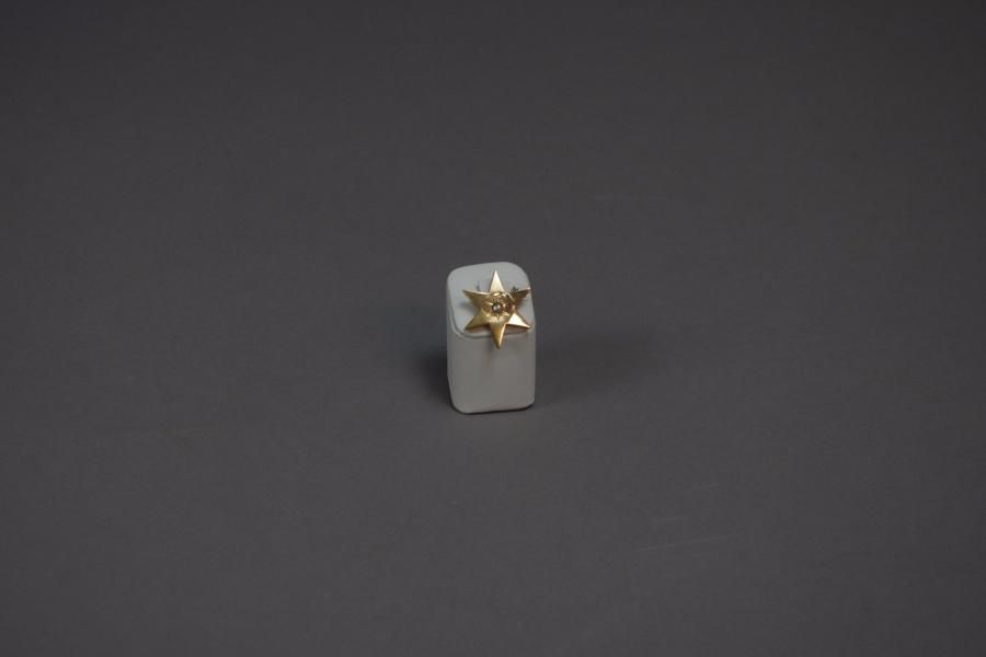 Null BROCHE étoile en or jaune ( 750 millièmes) ciselé, serti d'une demie perle.&hellip;