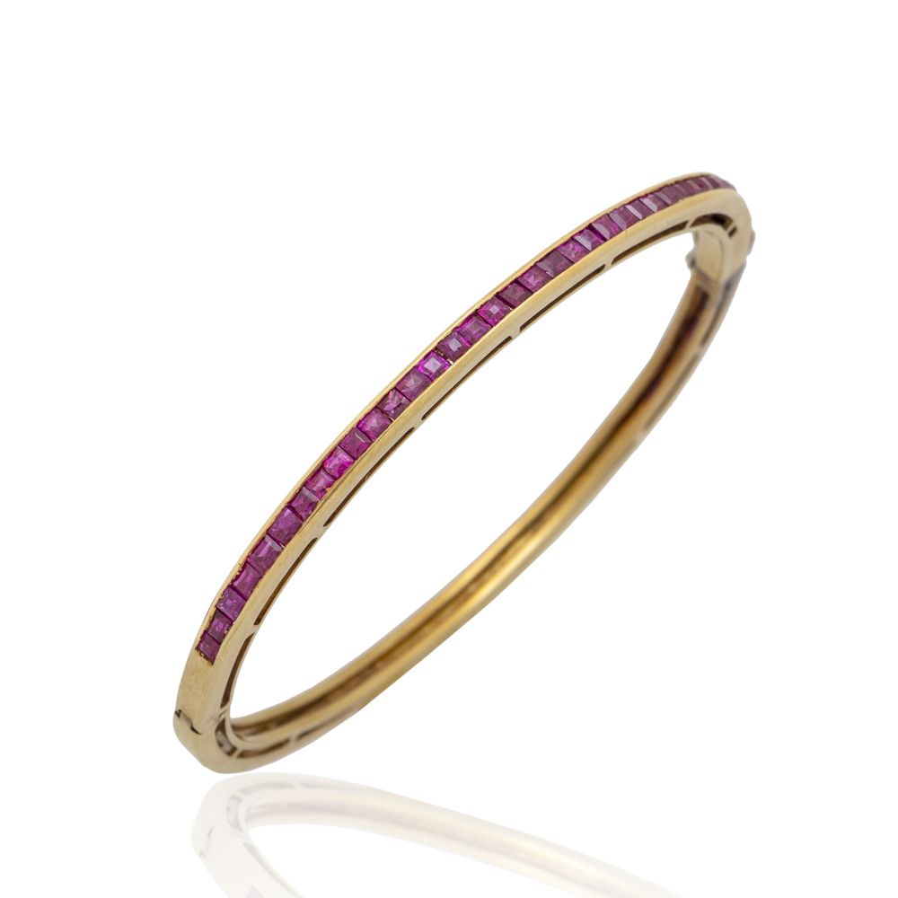 18kt yellow gold and ruby riviere cuff bracelet 重量为19克，卡莱式切割，隐形镶嵌，直径为6厘米。