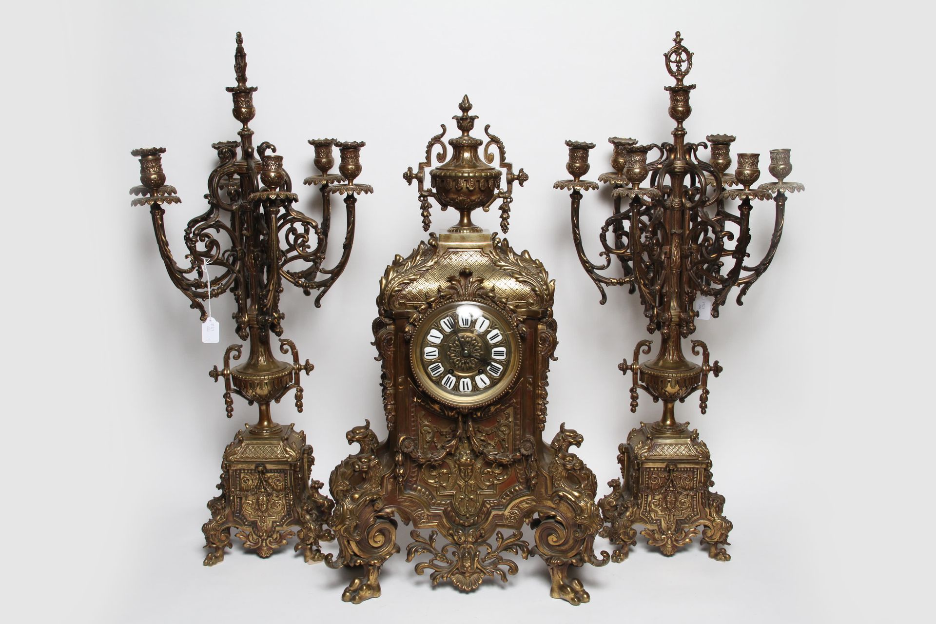 Null 饰有龙、花环、月桂、刺桐叶和火盆的九十年代青铜清漆壁炉，包括一个钟（高73 x 宽40 x 长16）和两个七灯烛台（高80 x 宽35）。