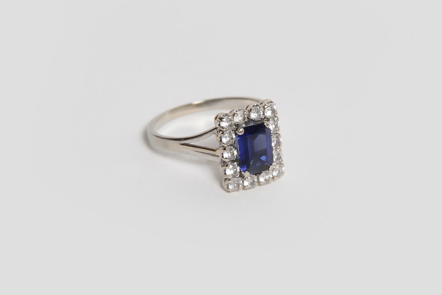 Null 镶嵌蓝宝石的白金戒指，周围环绕着白色的石头（总重5克）。