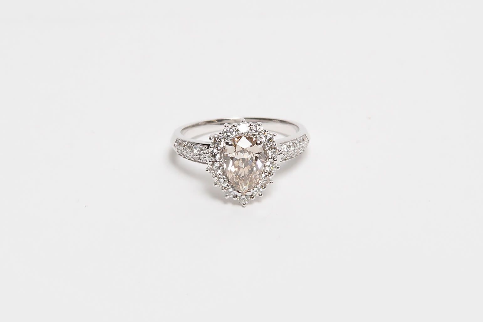 Null 18K金戒指，中间镶嵌一颗1.20克拉以上的香槟色梨形钻石，配以一串1克拉以上的钻石（总重4.20克）