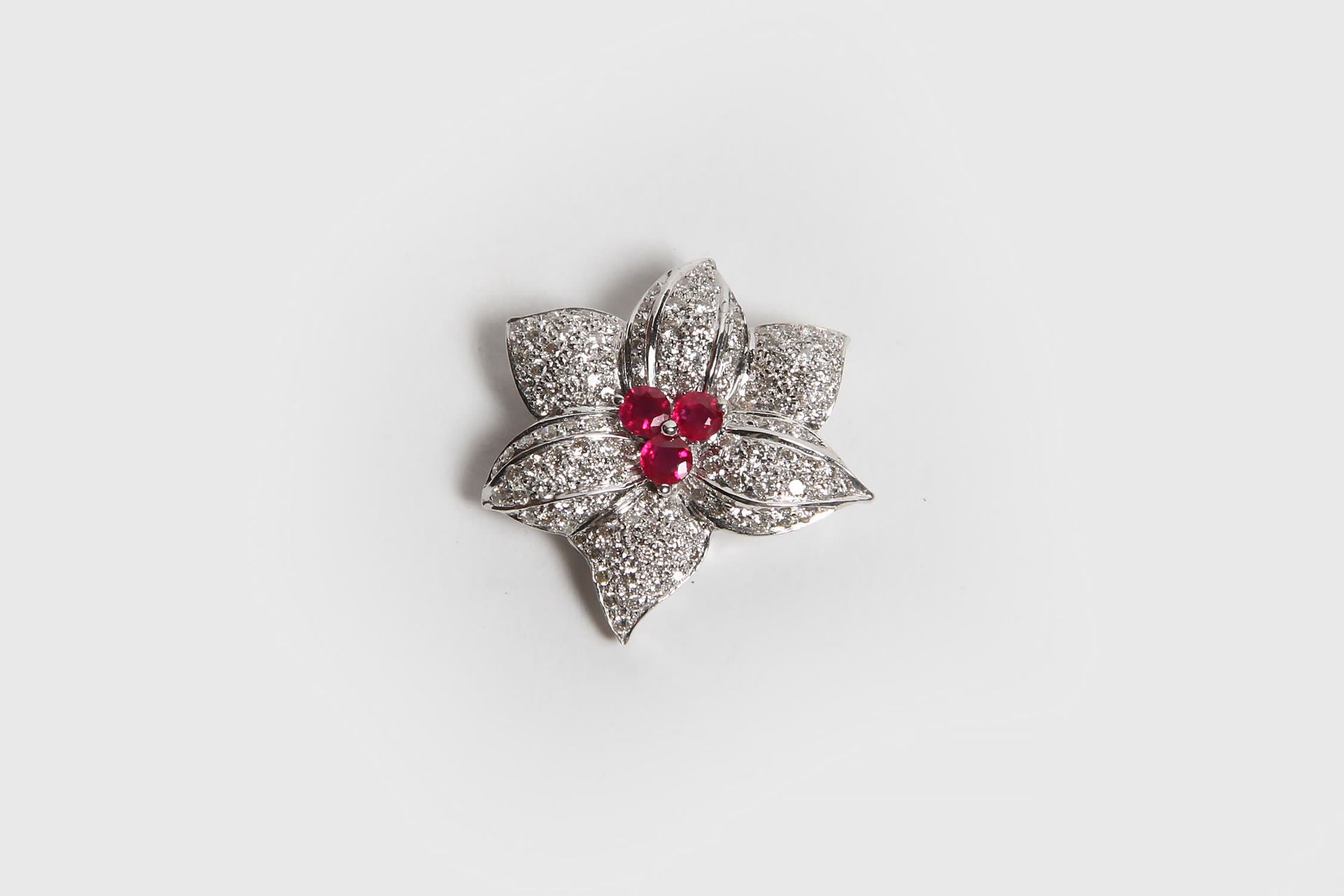 Null 750°/ooo金花夹（或吊坠），花瓣上镶有圆形钻石，花蕊上镶有三颗红宝石（总重8.7克）。