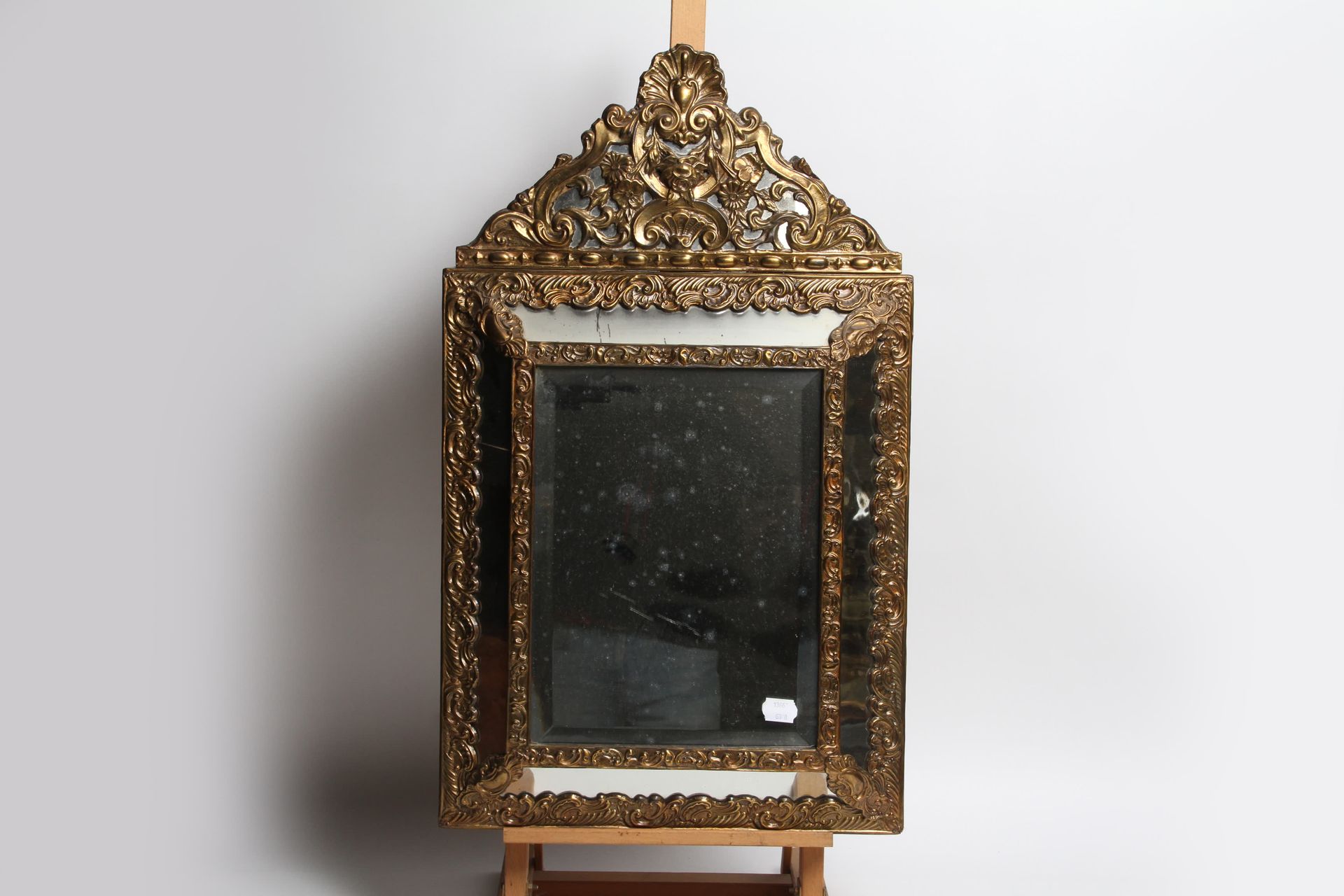 Null MIRROR WITH PEDIMENT IN EMBOSSED BRASS. 43,5x 73,5 cm.