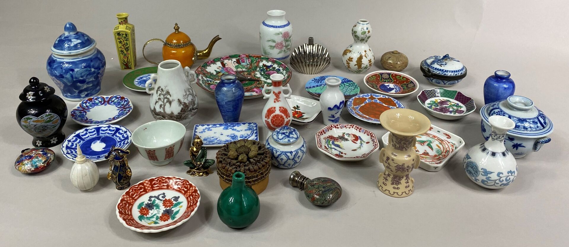 Null 包括花瓶、小盘子、茶壶、鼻烟壶和带有亚洲装饰的花、鱼和其他几何图案的有盖花盆在内的一套微型制品

(原样)