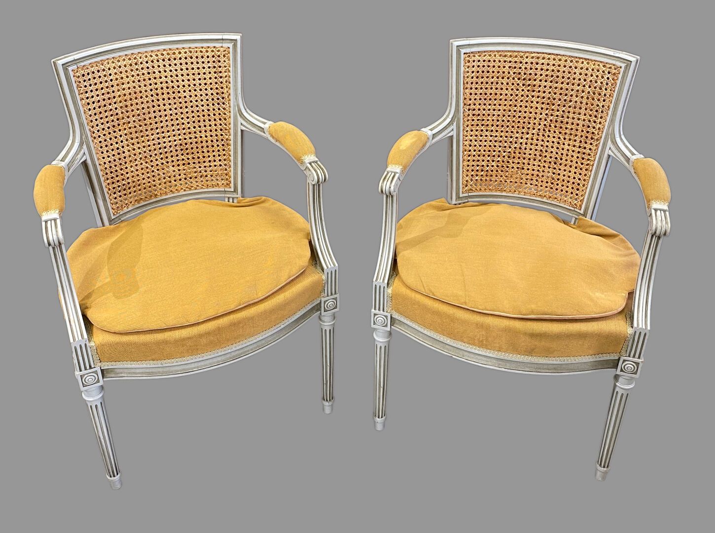 Null 一对白色漆面木雕扶手椅，梯形藤条靠背，卷曲的扶手，锥形和凹槽腿

路易十六风格