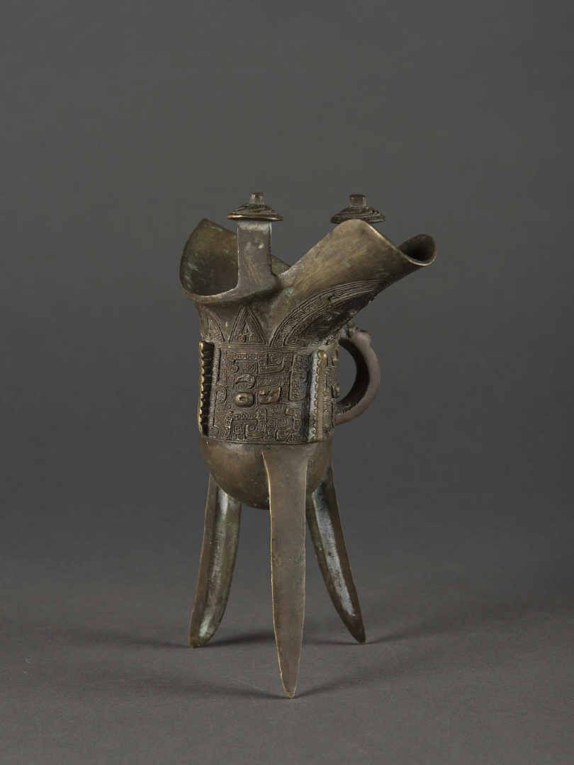 Null CHINE, Coupe libatoire en bronze à décor archaïque anse latérale, tripode

&hellip;