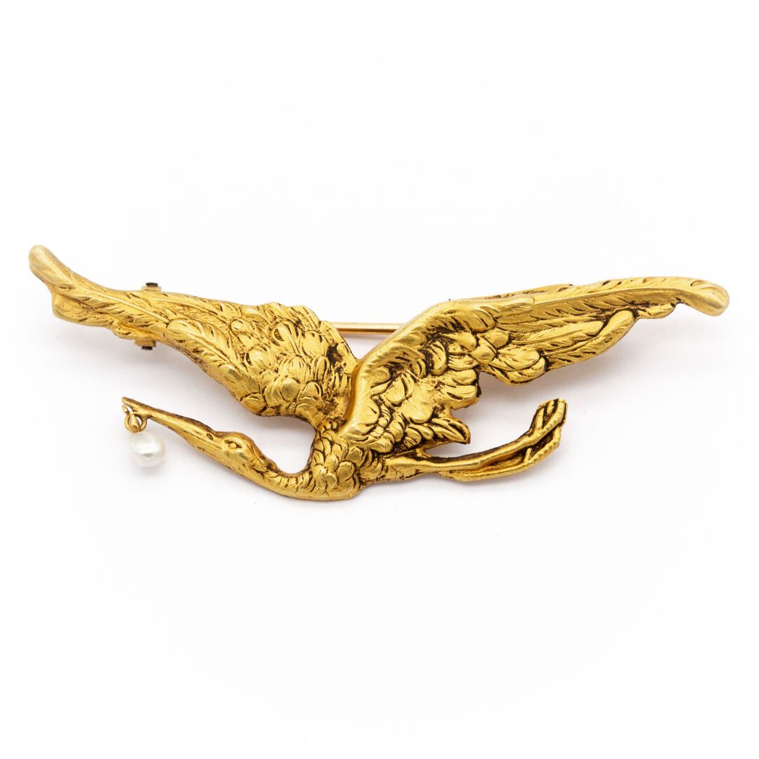 Null Broche en or jaune (750) 18K figurant une cigogne ailes déployées, tenant u&hellip;