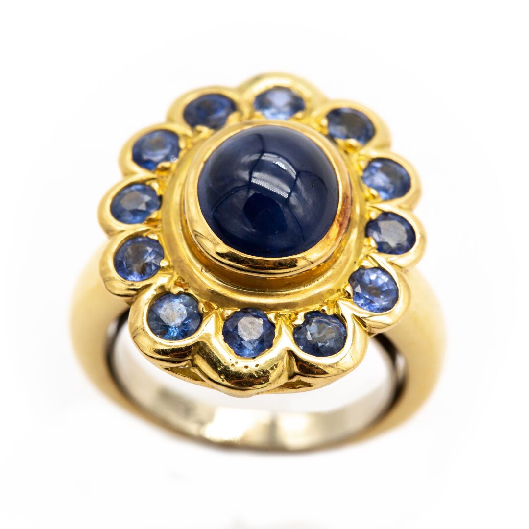 Null Daisy ring in 18K yellow gold, with a sapphire cabochon in the center surro&hellip;