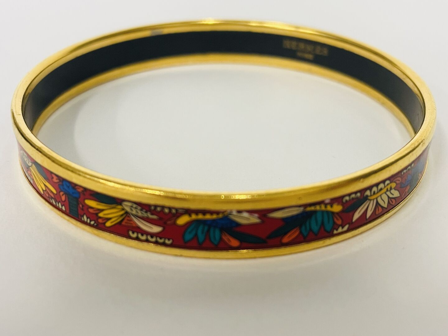 Null HERMES, bracelet émaillé à décor de rinceaux feuillagés sur fond rouge