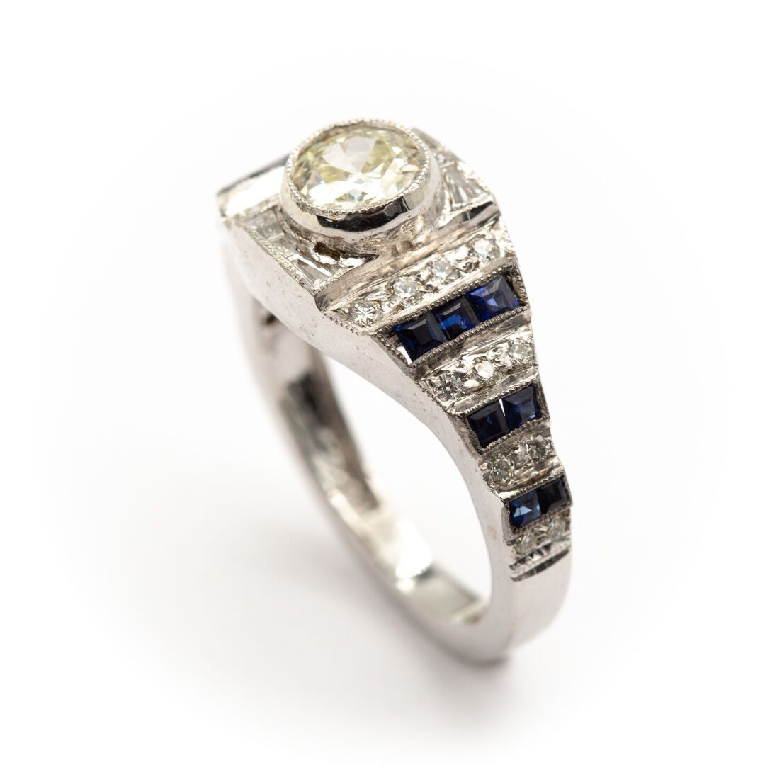 Null 18K白金带状戒指，一排排的钻石穿插着一排排的校准蓝宝石。

在中心有一颗较大的钻石。

重量 : 6,80 g

TDD 53 

猫头鹰