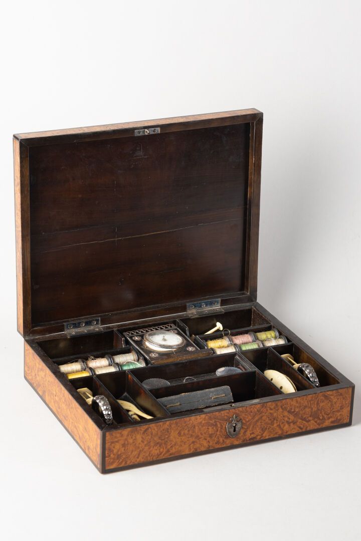 Null 胡桃木饰面的缝纫盒，包括一个带机械机芯的台钟，盖子上有小钢钉装饰。
约1820年。
高：7厘米 - 宽：39厘米 - 深：23厘米