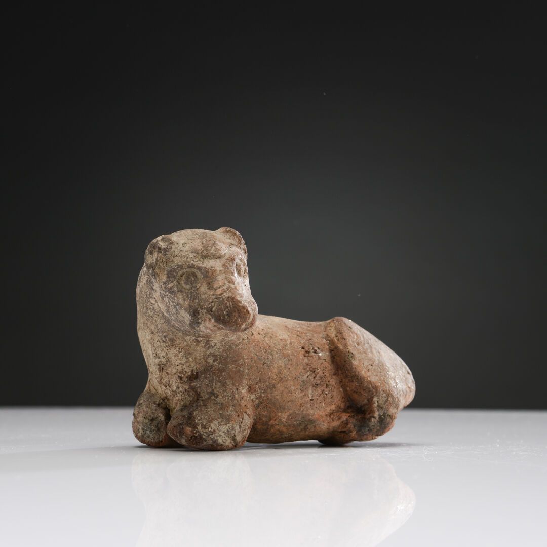 Null 卧狮雕像，头转向左边。
赭石色陶土。缺少腿和下巴。
埃特鲁里亚，公元前6-5世纪
长：12厘米。
出处：M. B. 收藏（里昂）。