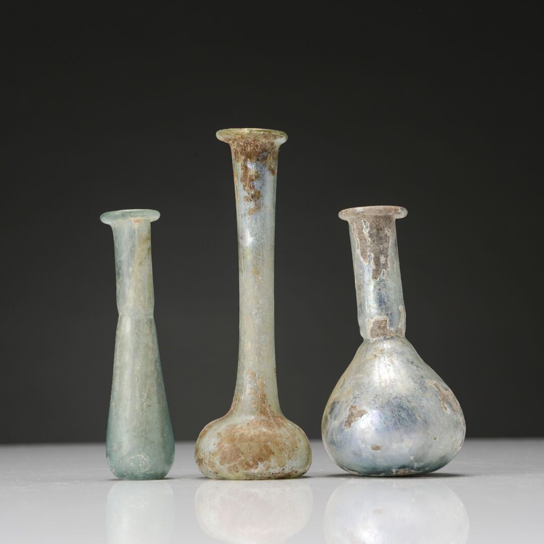 Null 一套三件的高颈香脂
五彩玻璃。唇部缺失。
罗马艺术，2-3世纪
H.9和9.5厘米。
1974年4月在一次拍卖会上获得
出处：M.B.的收藏（里昂）