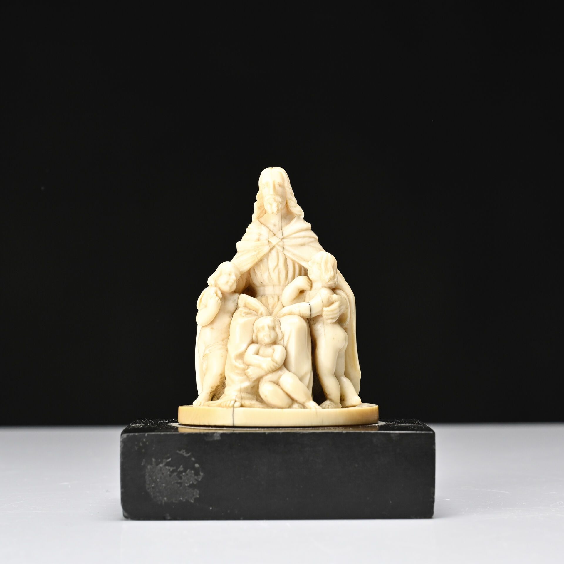Null Le Bon Pasteur. 
Sujet en ivoire sculpté. 
Le Christ accueillant trois enfa&hellip;