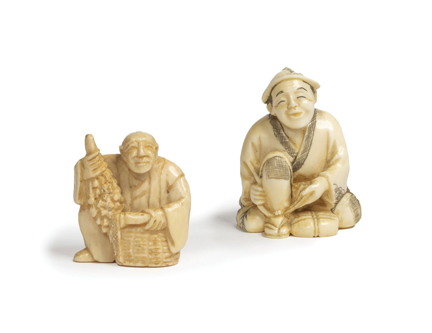 Null 
Lot de deux Netsuké en ivoire sculpté représentant un homme assis ajustant&hellip;