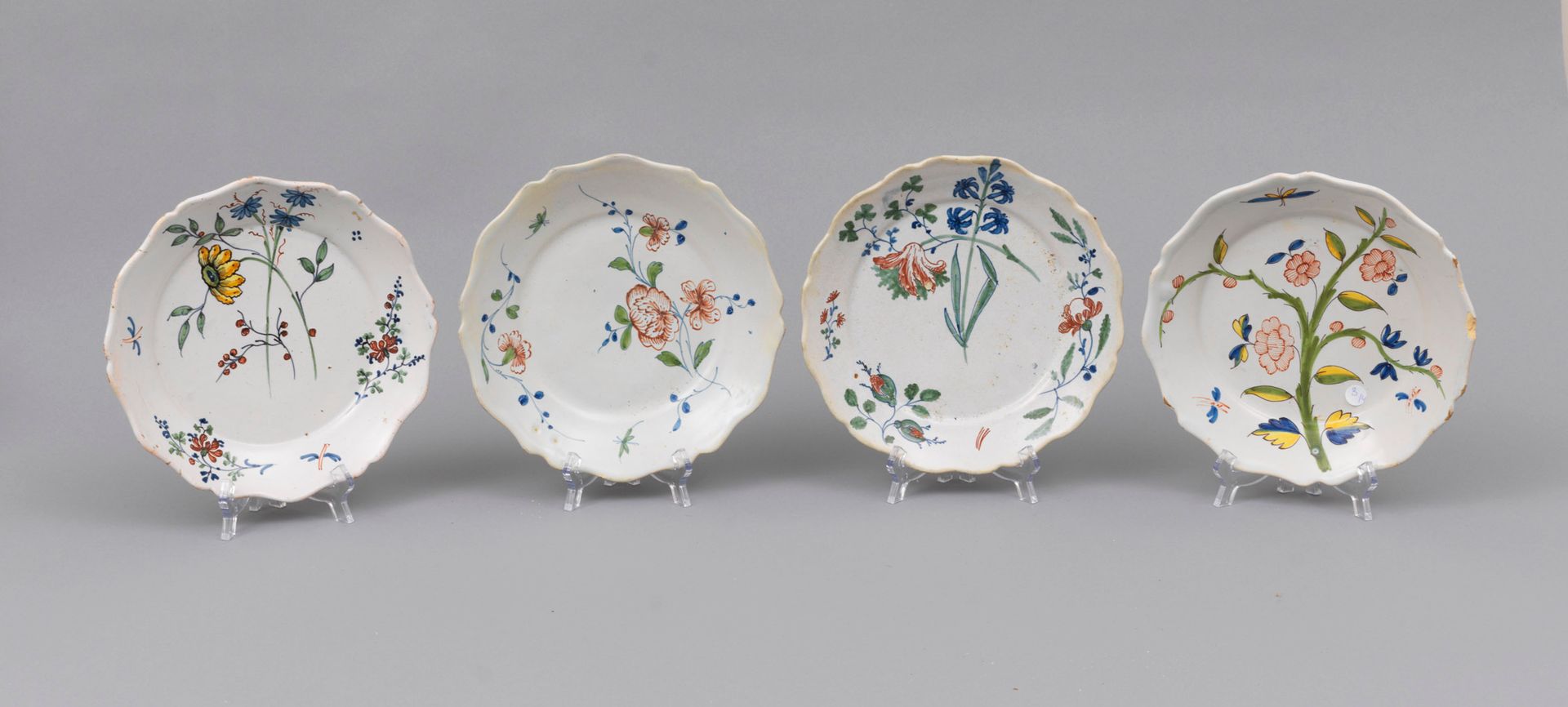 Faience Nevers 
内韦尔

四个陶盘，边缘有轮廓，有花茎和昆虫的完整多色装饰

18世纪

边缘有缺口 - 2个复原的盘子

直径23厘米