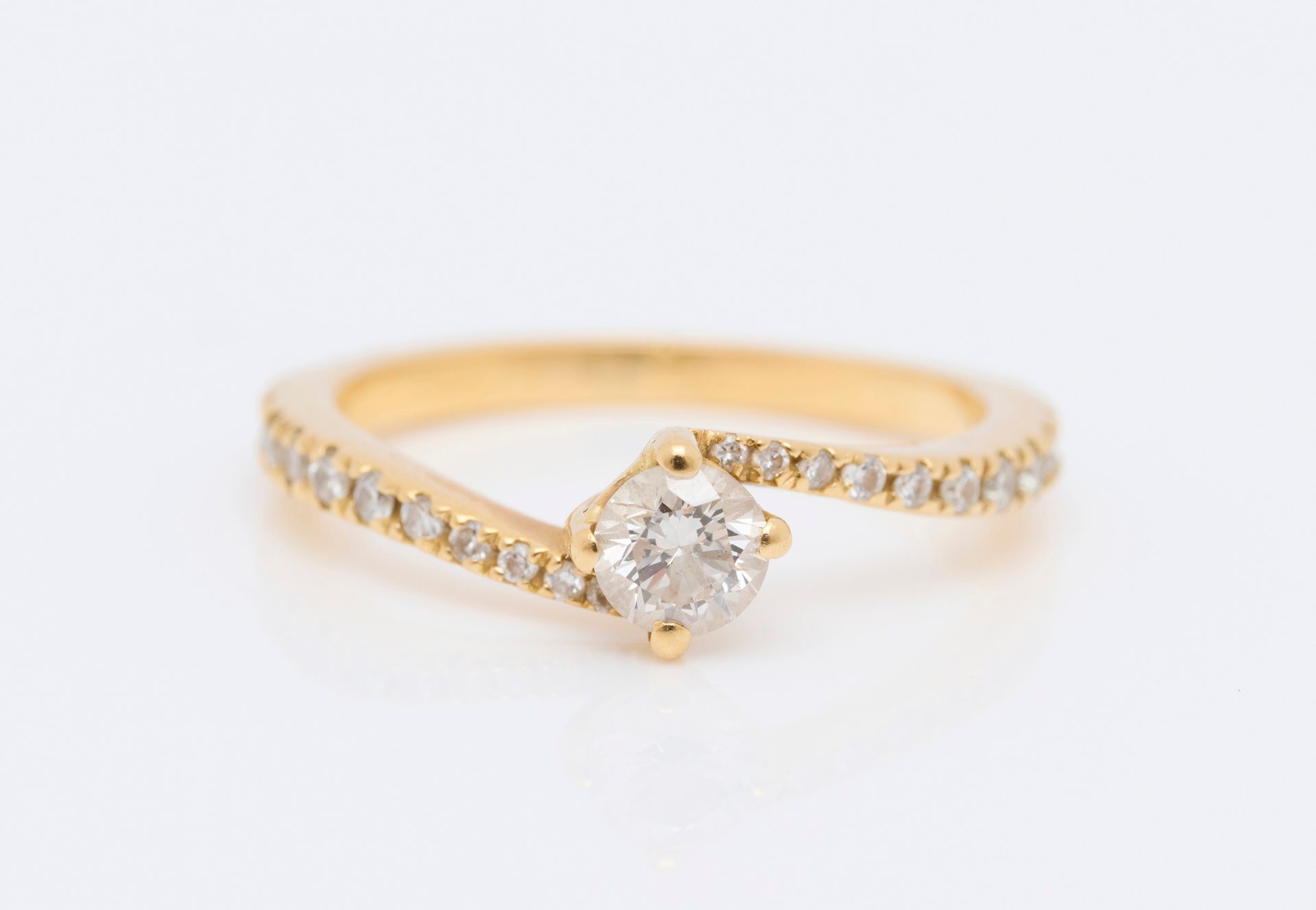 Bague 18克拉（750/000）黄金单颗戒指，中间是一颗明亮型切割钻石，约0.25克拉，镶嵌不对称的明亮型切割钻石。手指长度：52 - 毛重：2.68克。