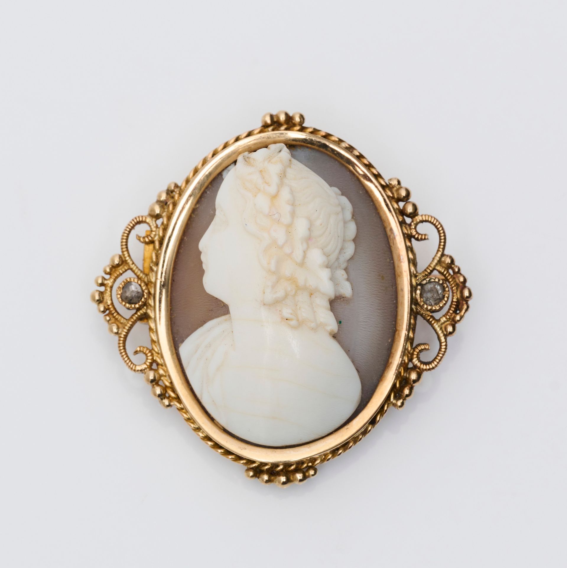 Broche 一枚18克拉黄金（750/000）椭圆形胸针，玛瑙上的浮雕代表一个女人的轮廓，镶嵌有卷轴装饰，并有小的玫瑰切割钻石。长度：3.1厘米 - 宽度：3&hellip;