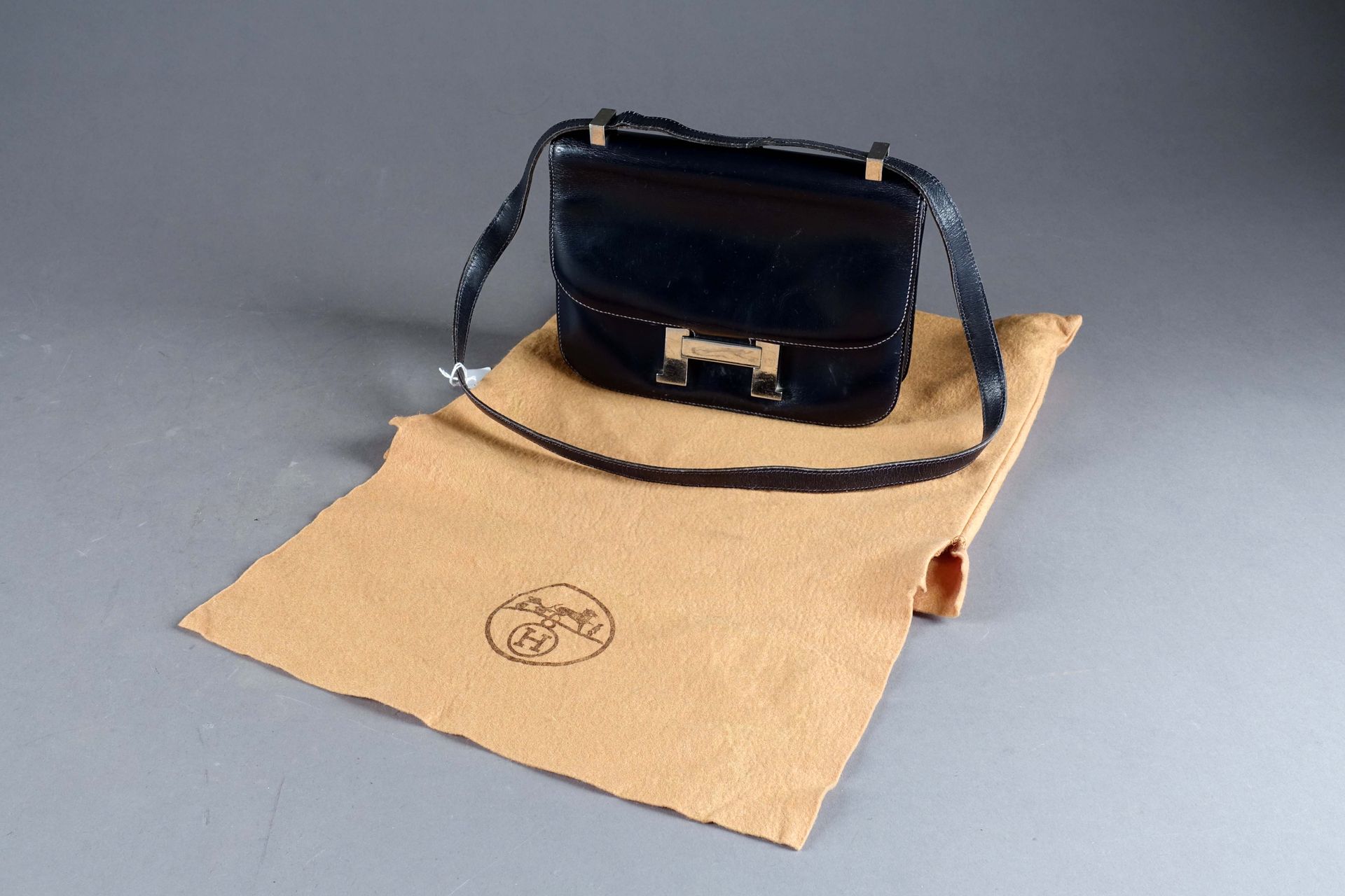 HERMES - PARIS. 手提包，模型 "Constance"。有 "H "形的金属扣。三个内袋，一个拉链，一个后袋。黑色皮革。约1970年。签名：Her&hellip;