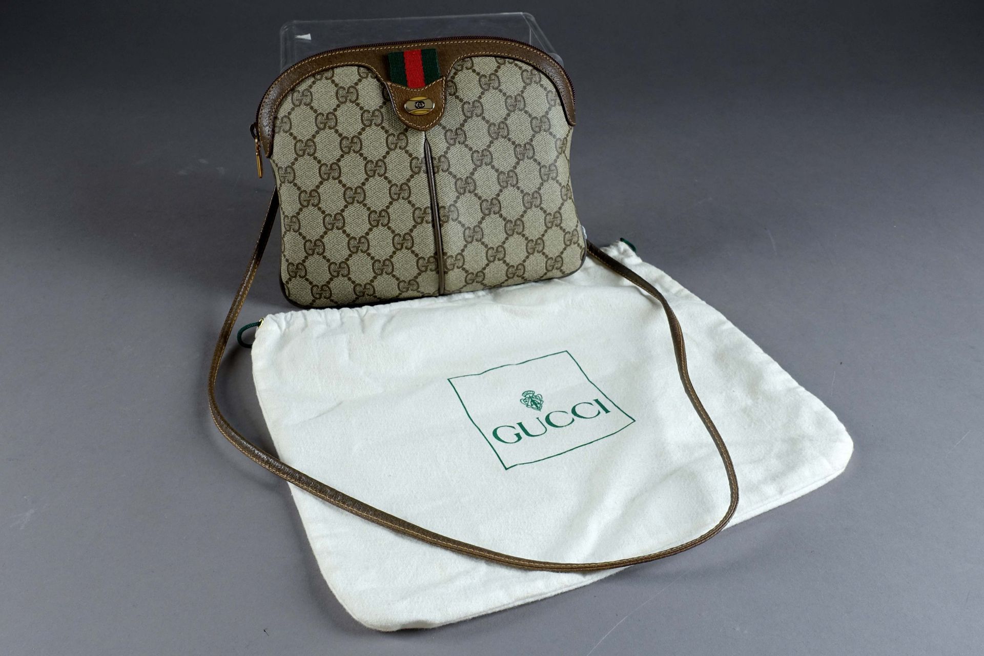 Gucci “Accessoty Collection“. 肩包。有图案的塑料帆布和棕色皮革。一个内隔间，用拉链封闭。尺寸：22 x 19厘米。近乎全新。带防尘&hellip;