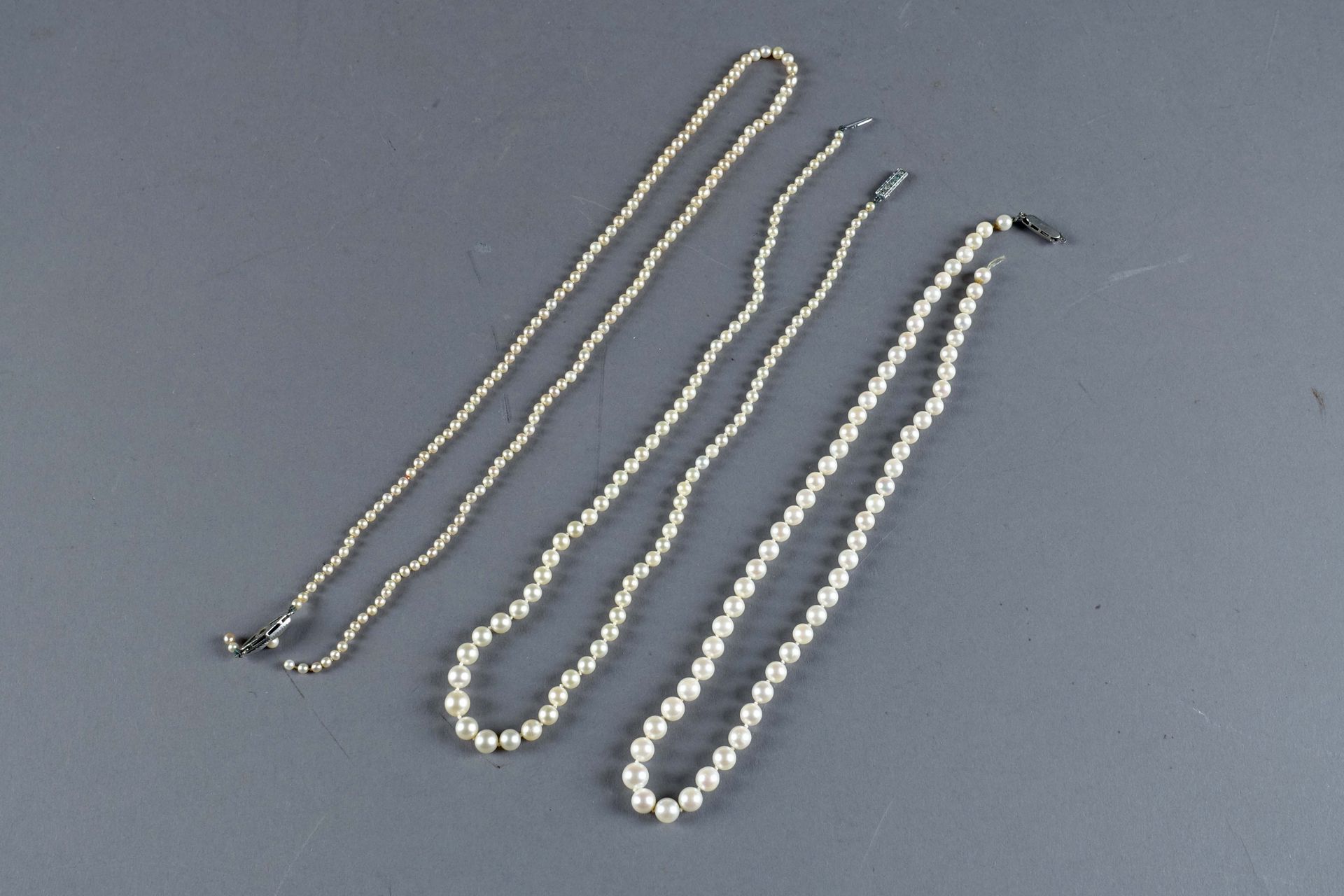 Trois colliers de perles de culture. (Deux à restaurer).