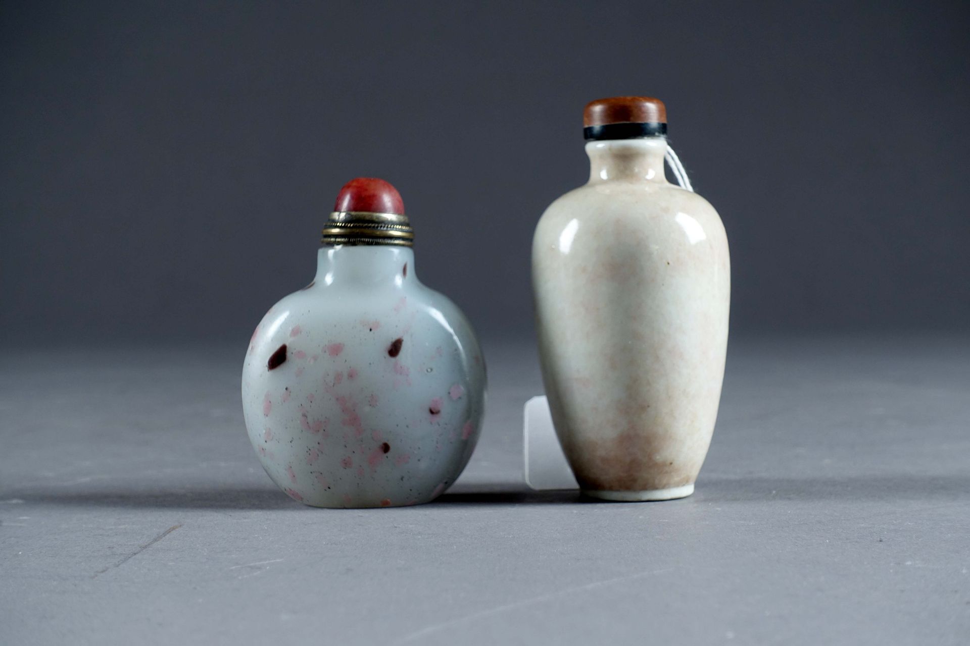 Deux Tabatières. 一个是罐子形式的瓷器（高：8厘米），另一个是带有彩色内含物的乳白色玻璃的扁平体（高：7厘米）。中国。状态 : 无事故。