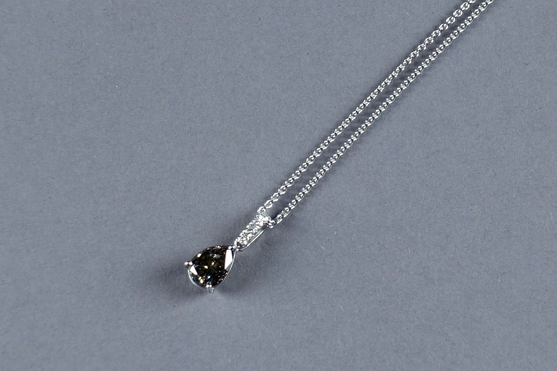 Pendentif et son Coulant. 镶有一颗梨形切割的黑钻石（约2克拉21），并在圈上有三颗明亮式切割钻石（约0克拉12）。镶嵌在18K白金中。&hellip;