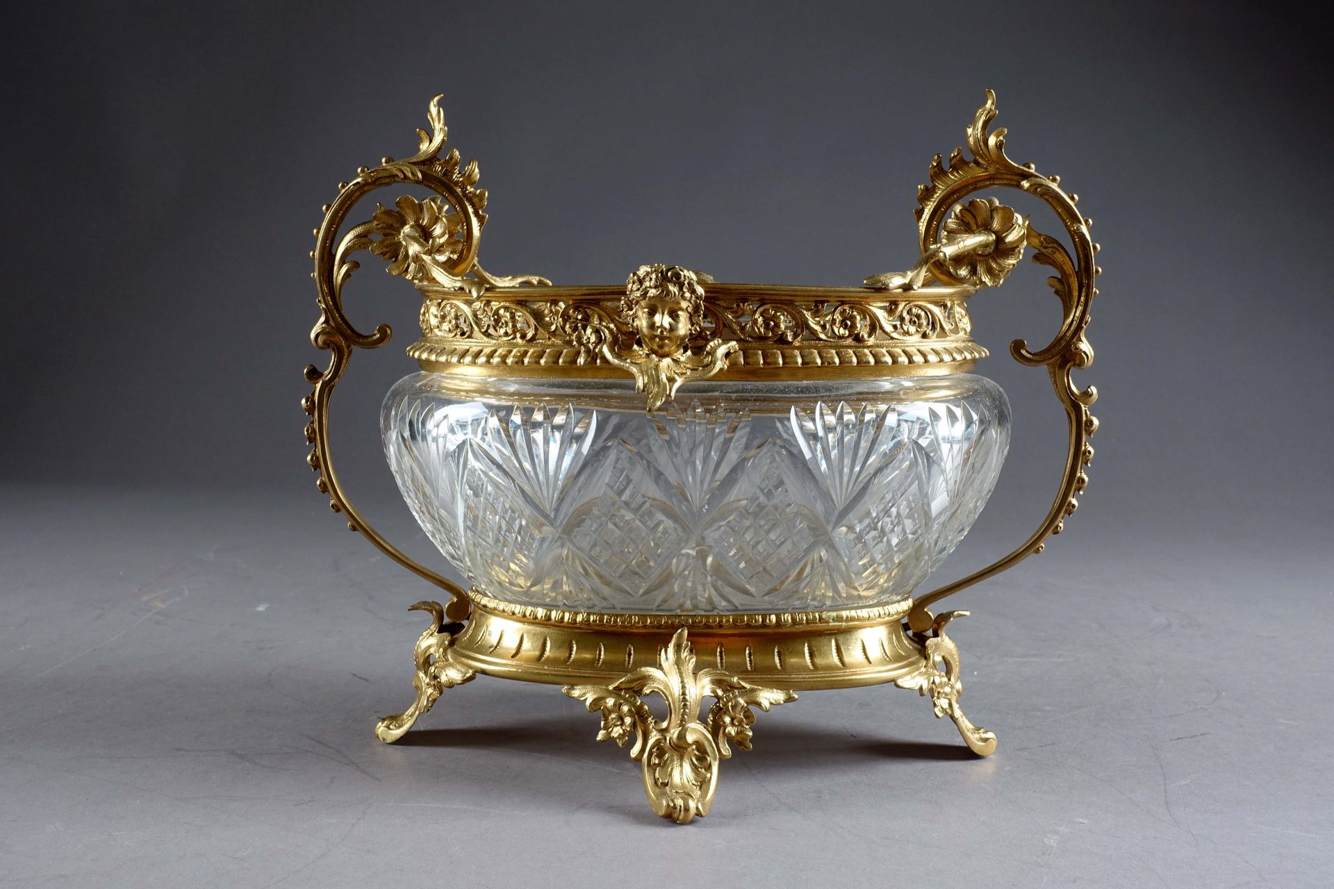 Vase corbeille Napoléon III. 无色切割水晶。鎏金铜安装，带罗盖尔脚和把手。颈部有镂空的画廊，上面有两张戴花的脸。19世纪末的作品。尺&hellip;