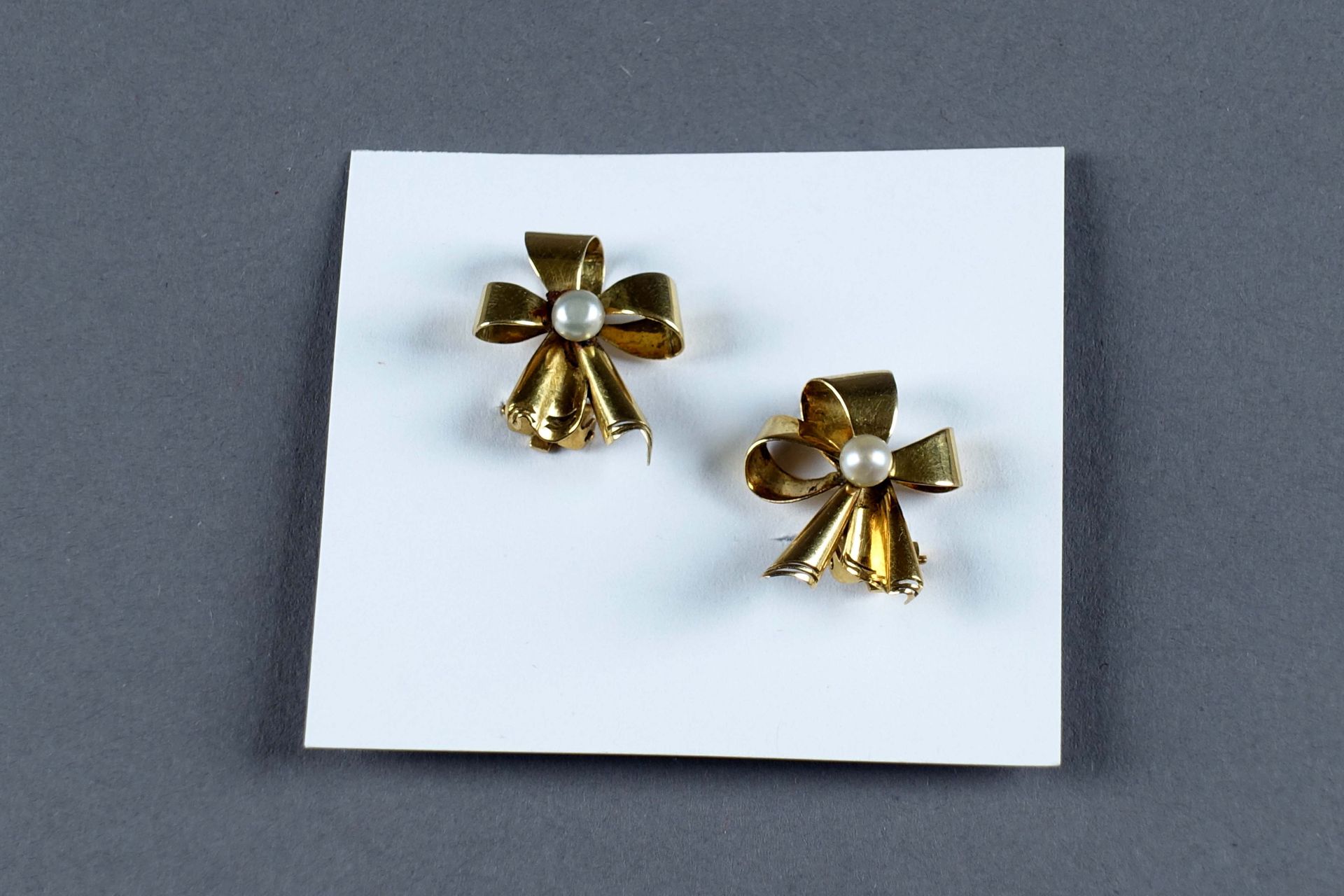 Paire de Clips d’Oreilles. 时尚的蝴蝶结上镶嵌着两颗养殖珍珠。镶嵌在18克拉的黄金中。重量：4.5克。