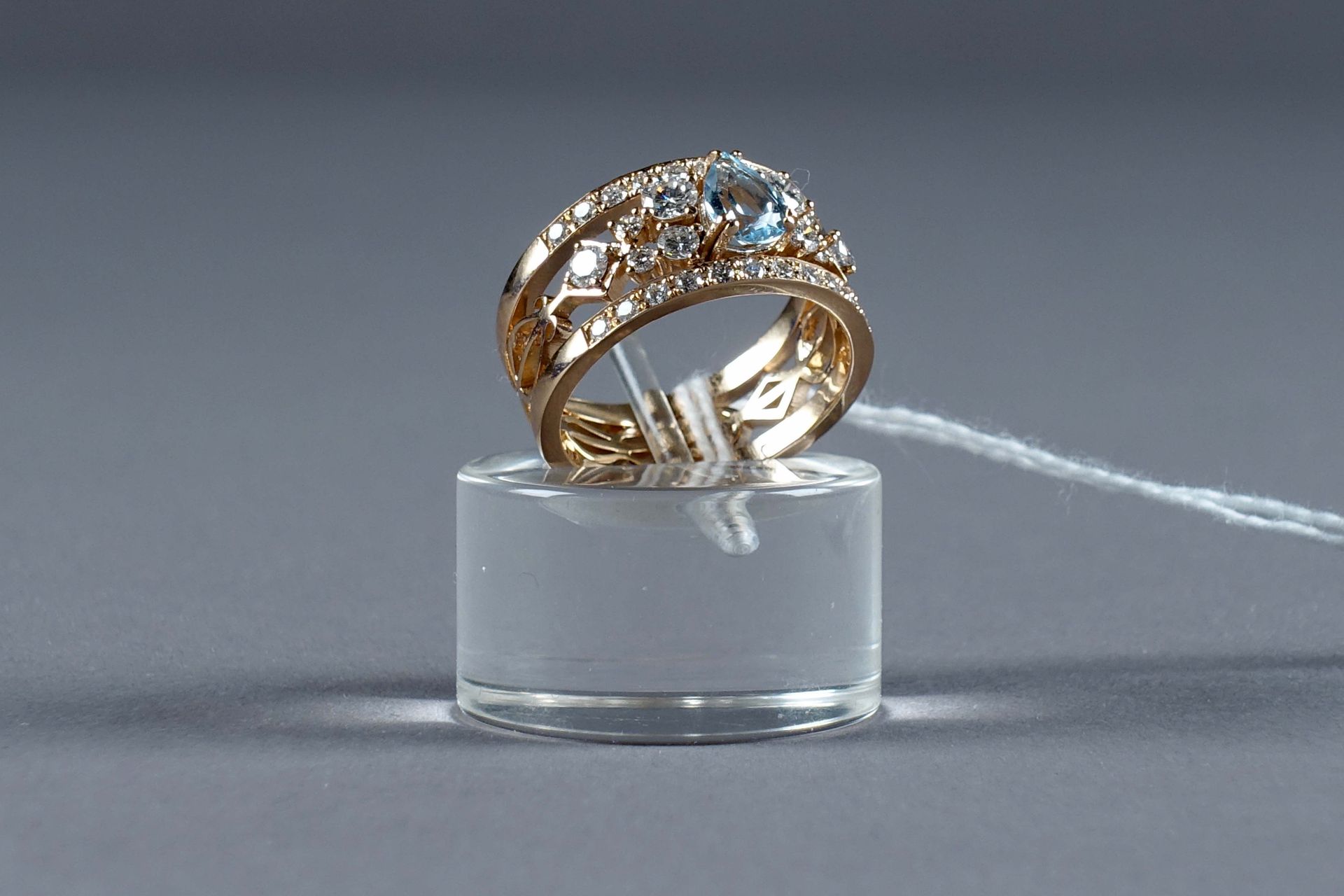 Bague de Dame. 镶嵌一颗梨形切割的蓝色托帕石（约0克拉65），并以三十二颗明亮式切割的钻石（约0克拉80）作为装饰。18K玫瑰金的造型和镂空镶嵌。&hellip;