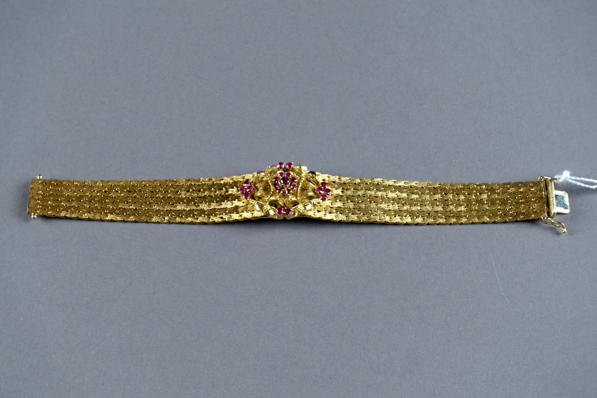 Bracelet Manchette. 饰以中央镂空图案，并镶有21颗圆形切割红宝石（约0.30克拉）。编织的18K黄金镶嵌。重量：49,4克。长度：17.5厘&hellip;
