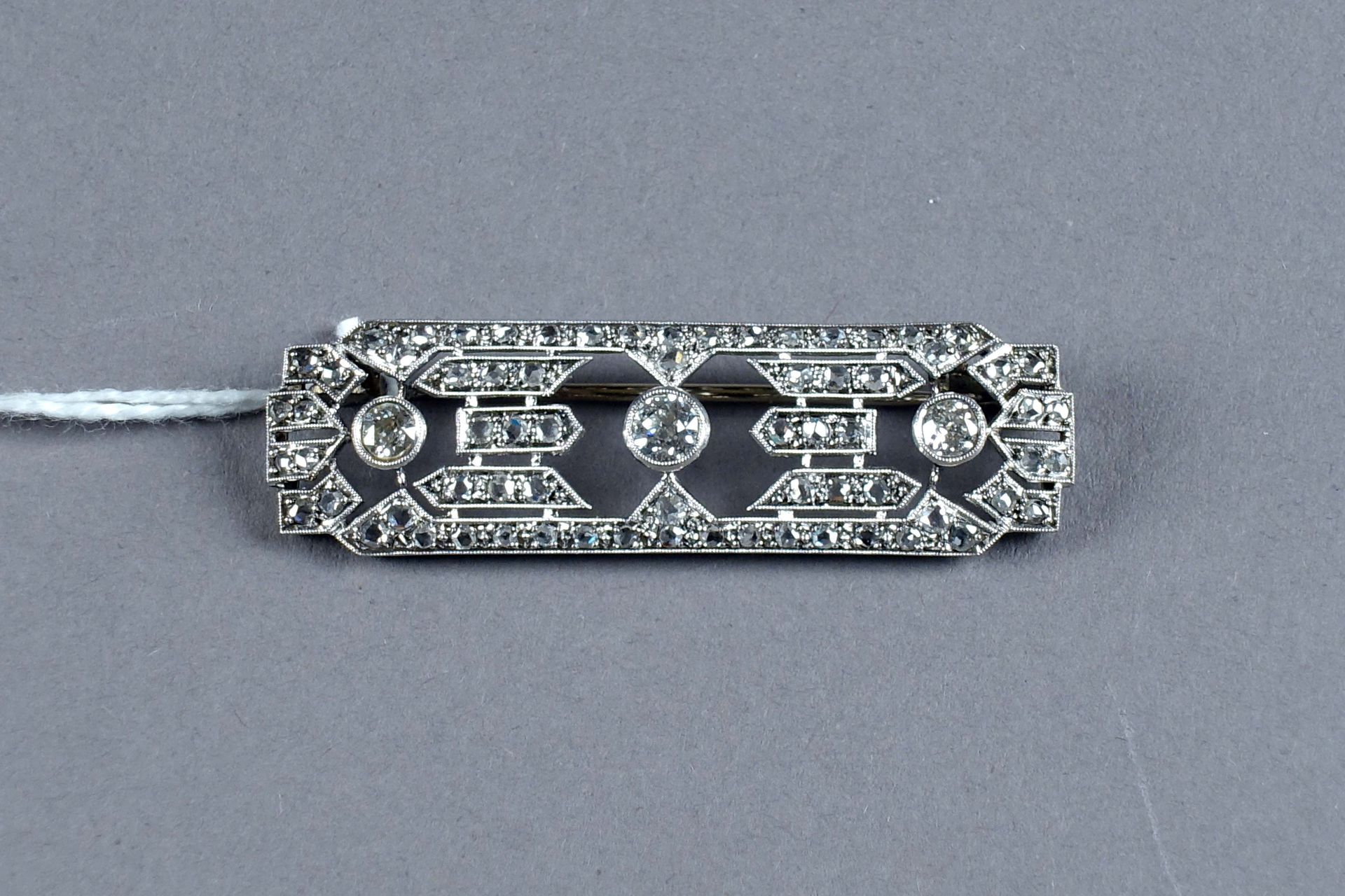 BROCHE ART DÉCO. 镶有三颗老式切割钻石（约0.70克拉），并有70颗玫瑰式切割钻石作点缀。镶嵌在18K白金中。重量：8克。