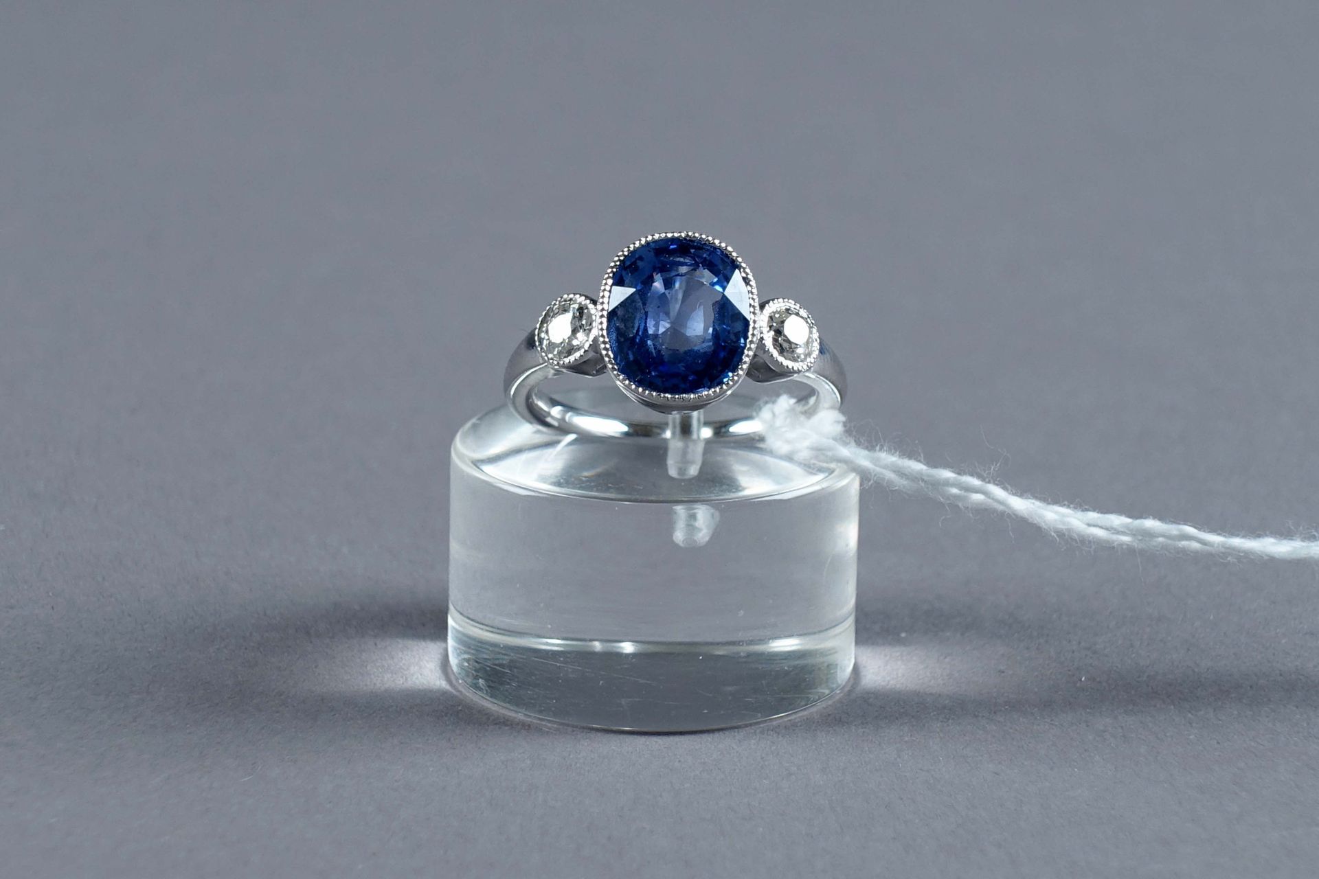 Bague de Dame. 镶嵌着一颗椭圆形蓝宝石，可能是缅甸的（约3克拉77），两侧是两颗老式切割钻石（约0克拉40）。镶嵌在18K白金中。重量：5.2克。&hellip;