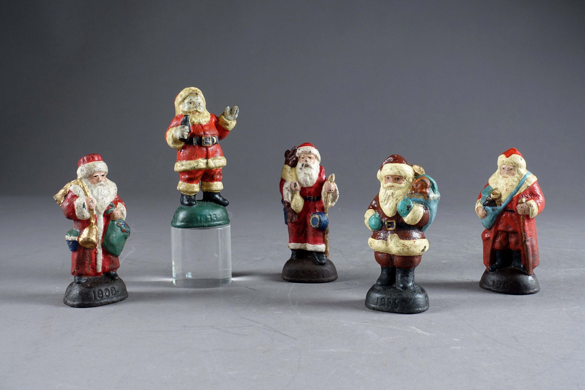 Cinq figurines. Représentant le Père Noël et ses attibuts. Fonte de fer émaillée&hellip;