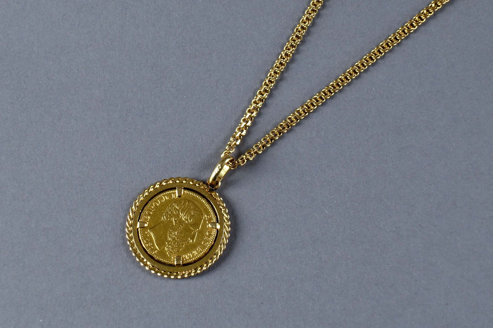 Pendentif et sa Chaîne. 镶嵌有一枚1876年的比利时利奥波德二世20法郎的硬币。镶嵌在18K黄金中。重量：6.4克（21.6克拉）和18&hellip;