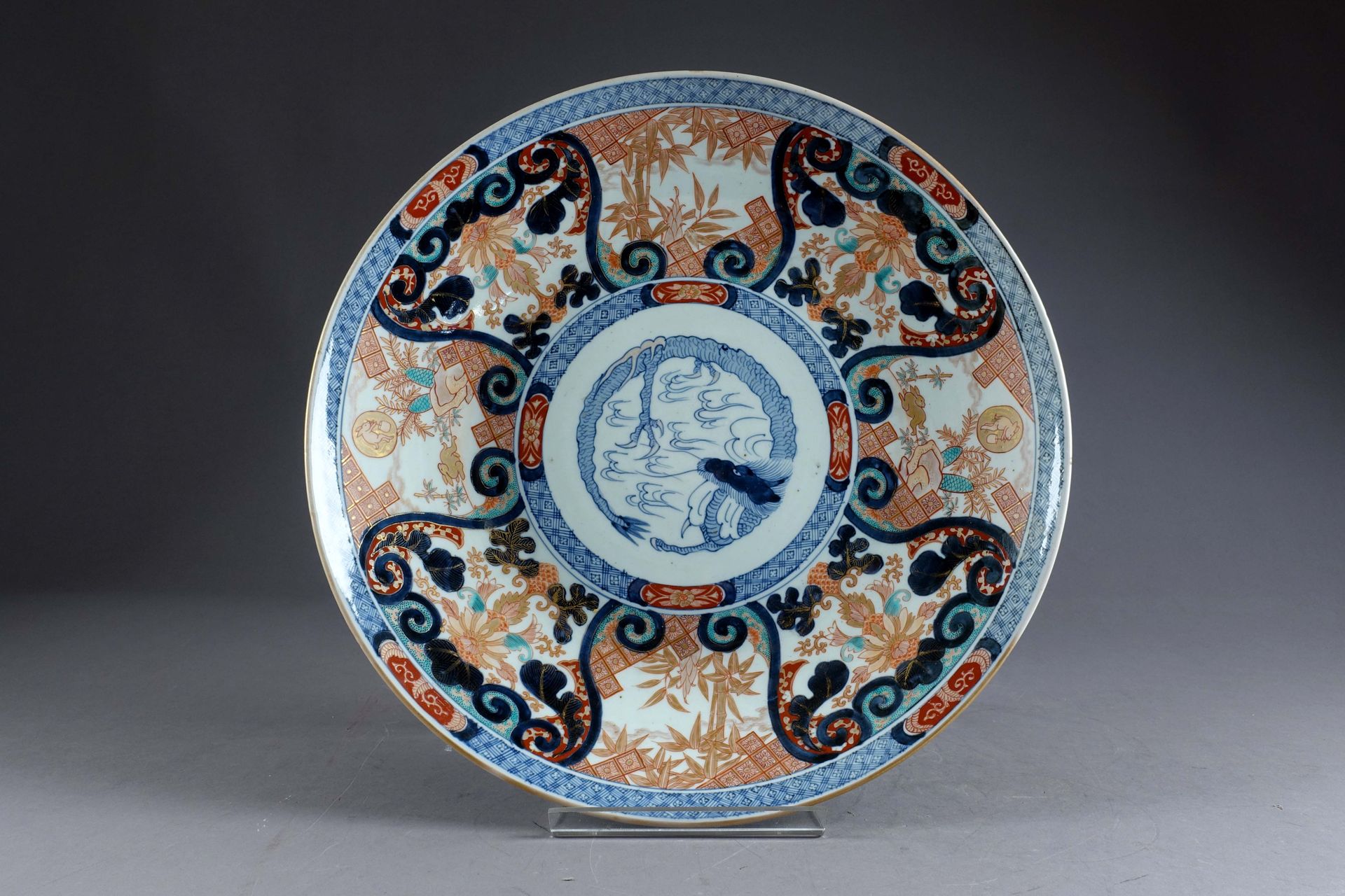 JAPON. A large round Arita porcelain dish with a coiled dragon in the center sur&hellip;