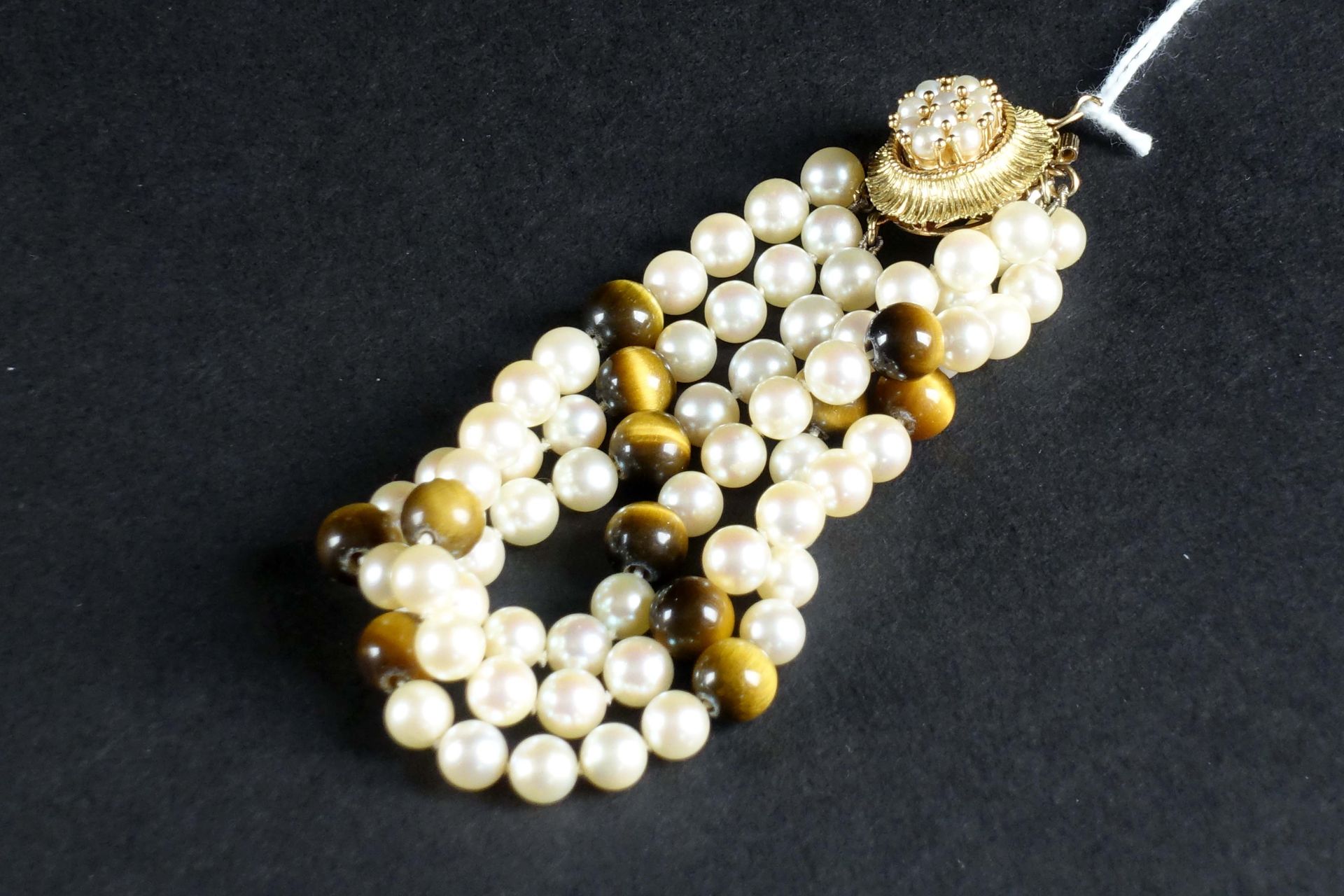 Bracelet à trois Rangs de Perles de Culture. 点缀着猫眼珍珠。18克拉黄金镶珍珠的扣子。长度：19厘米。