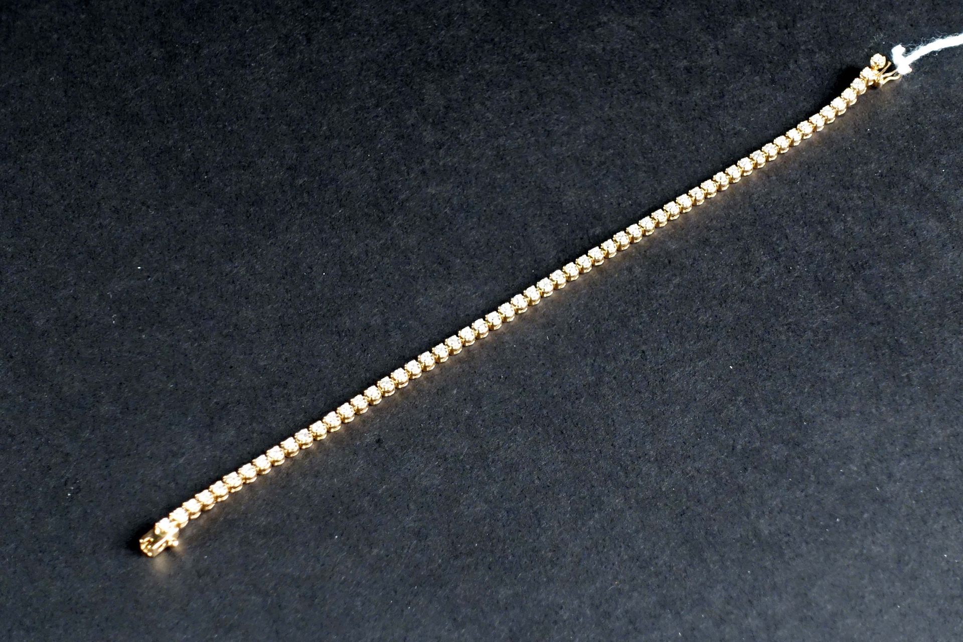 Bracelet Rivière. 镶嵌了57颗明亮式切割钻石（约2克拉）。镶嵌在18K黄金中。重量：8.6克。长度：18厘米。