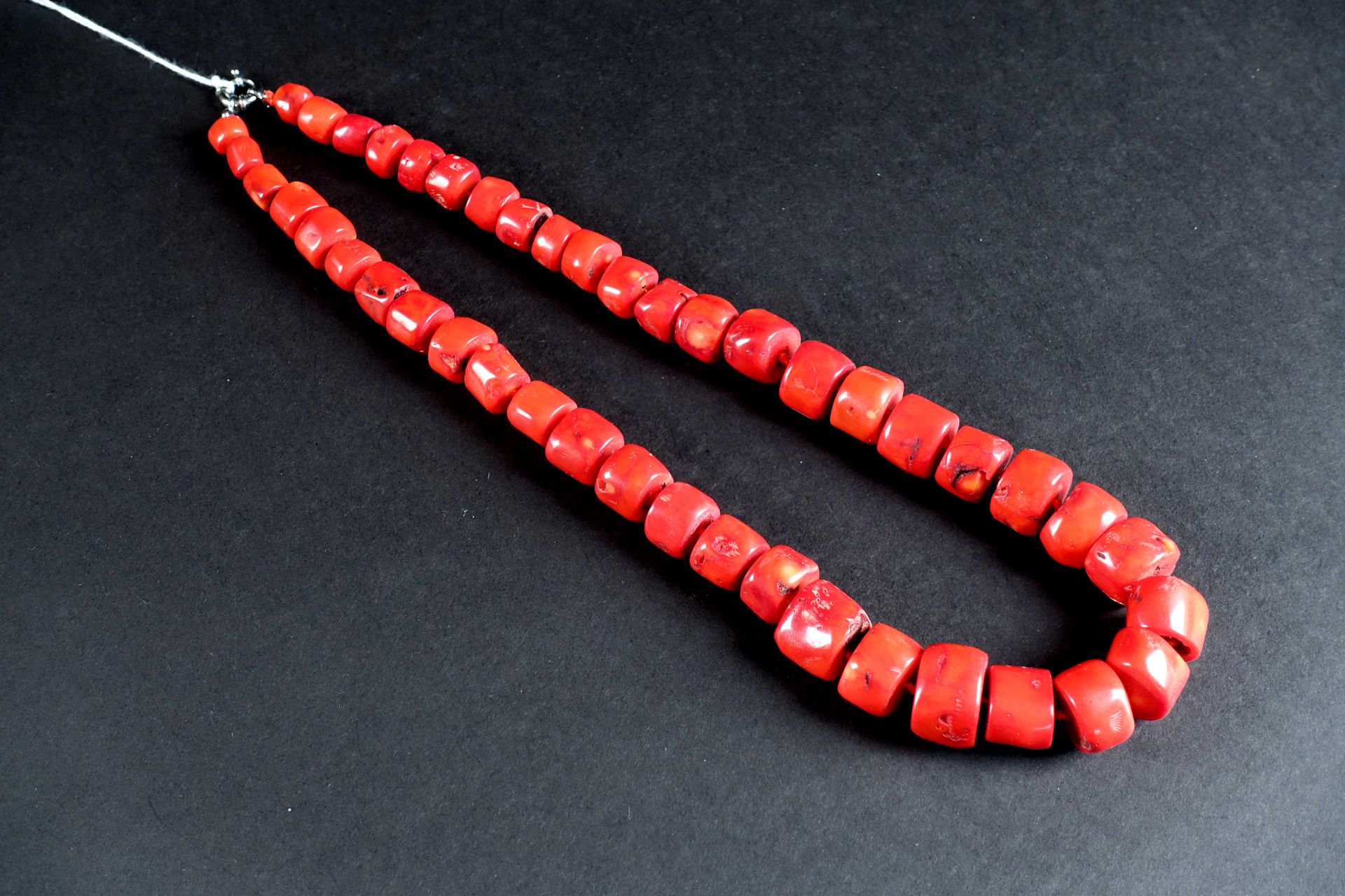 Collier en Chute de Perles de Corail Rouge. Fermoir en argent. Longueur : 64 cm.