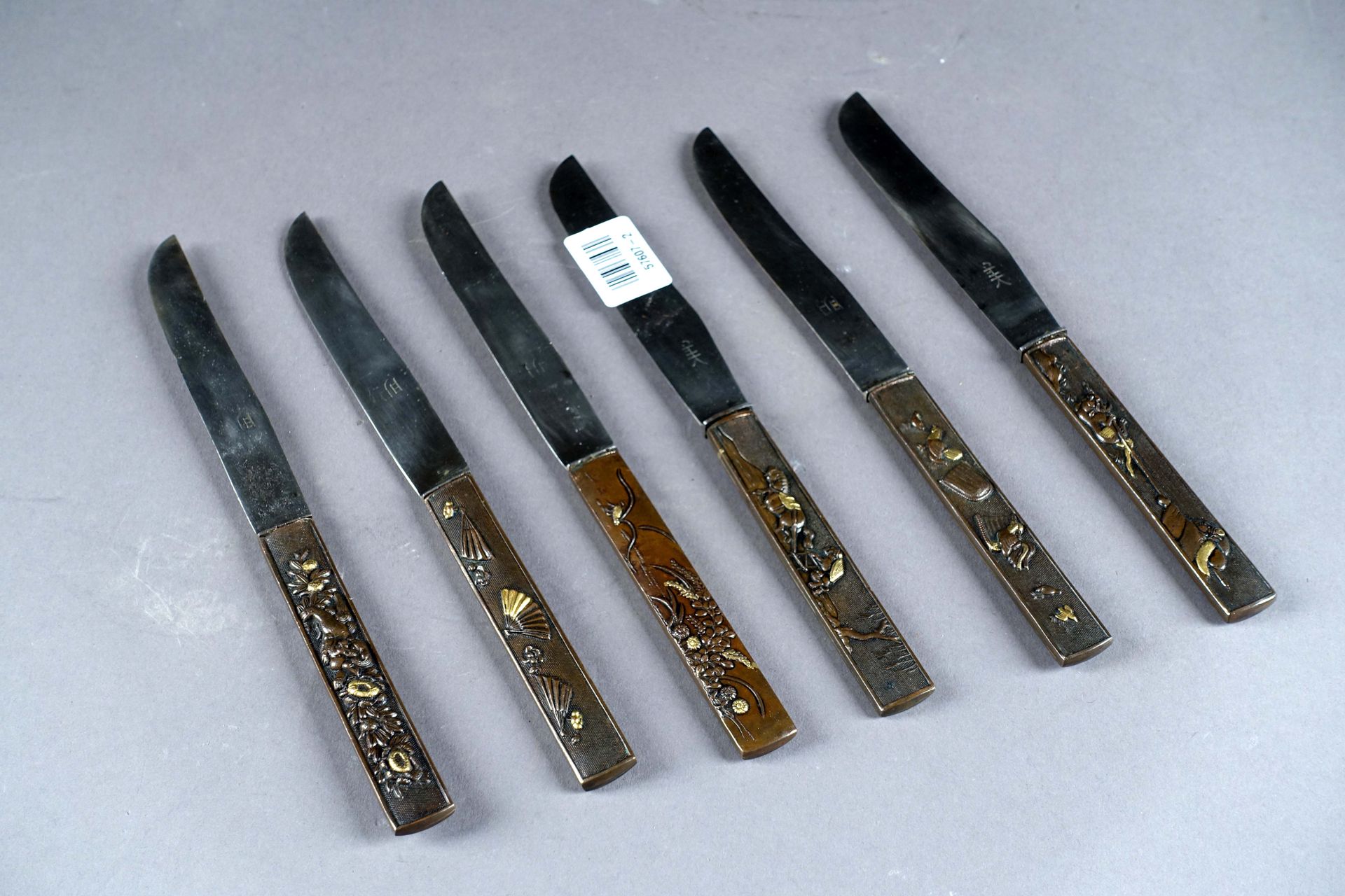 Suite de six couteaux “Kozuka“. 铜制手柄上有浮雕装饰。冲压的金属刀片。日本。明治时期。长度：20.5厘米。