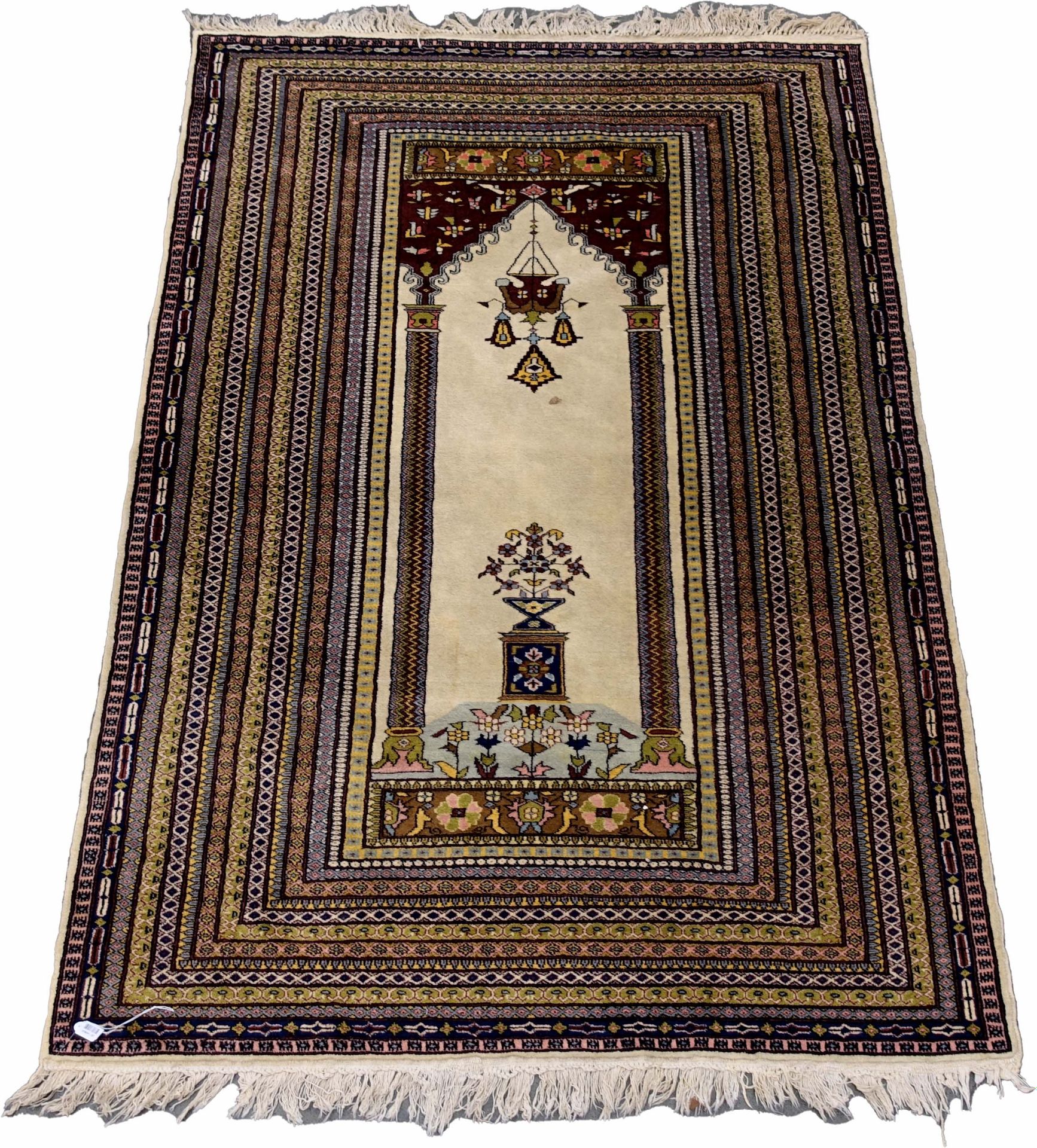 Carpette de Prière. Le fond, clair, présente un mihrab à double colonne et une l&hellip;