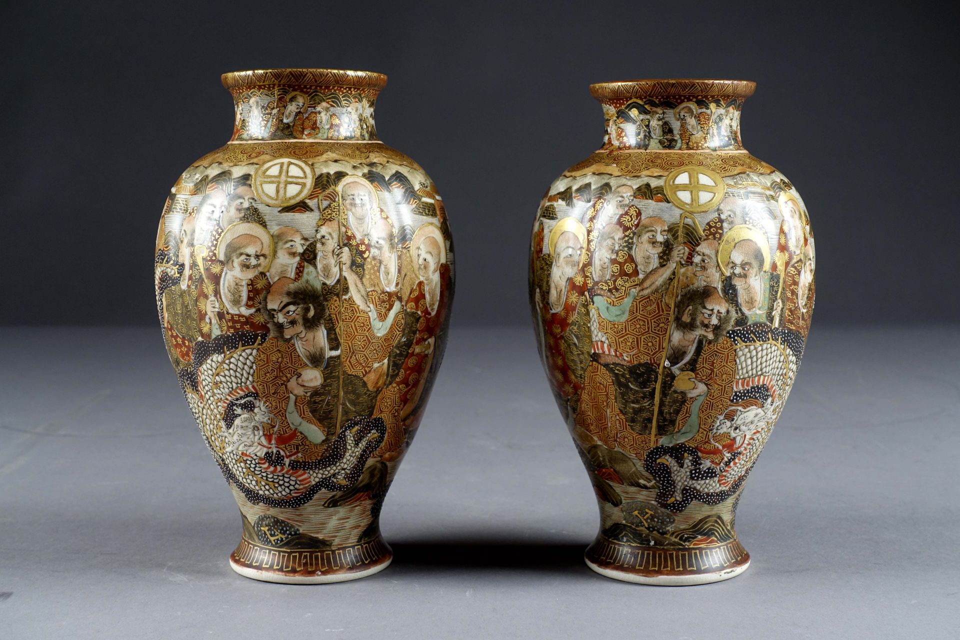 Satsuma. 一对有直棱的巴斯特花瓶。装饰有镜子、龙和众多阿罗汉，背景是山。Iro E Kinsai的釉面石器。日本。明治晚期。签名。高度：19厘米。状态：&hellip;